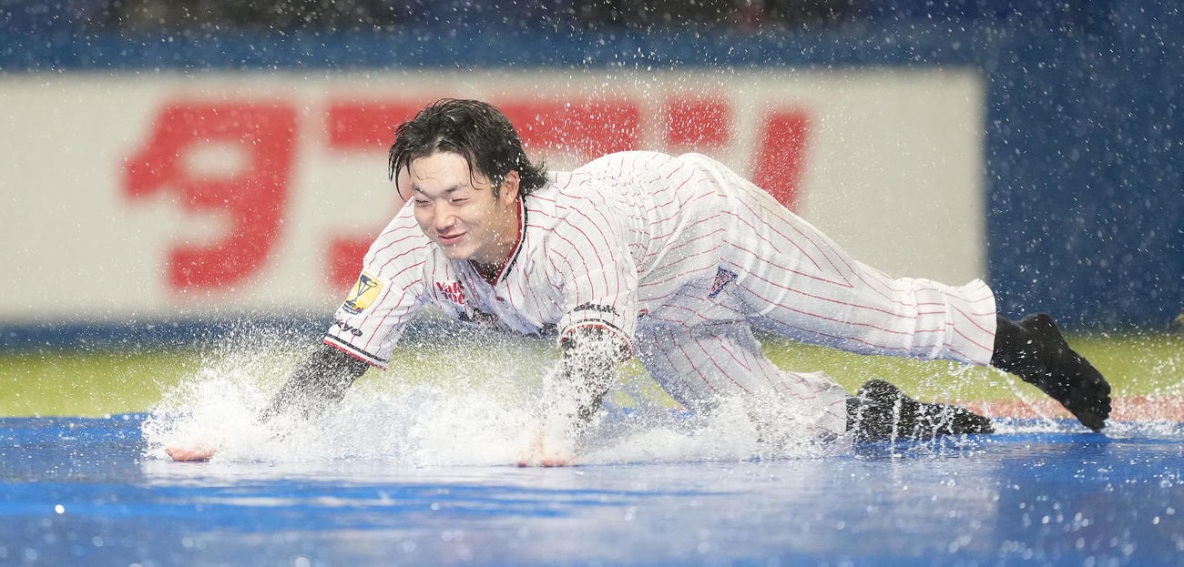 雨天中止となり、本塁へヘッドスライディングするヤクルト長岡（撮影・鈴木みどり）