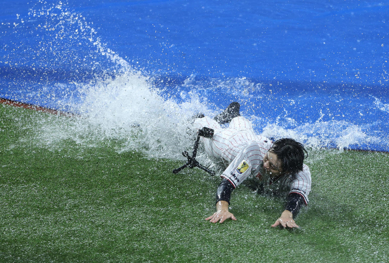 ヤクルト対阪神　　雨天中止となり、本塁へヘッドスライディングするヤクルト長岡だが勢い余ってカメラに激突する（撮影・井上学）