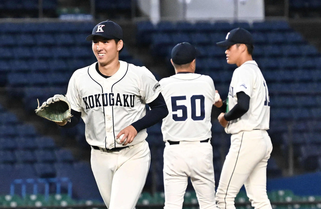 国学院大対青学大　8回裏、降板した国学院大・武内（左）は笑顔でベンチへ引き揚げる（撮影・滝沢徹郎）