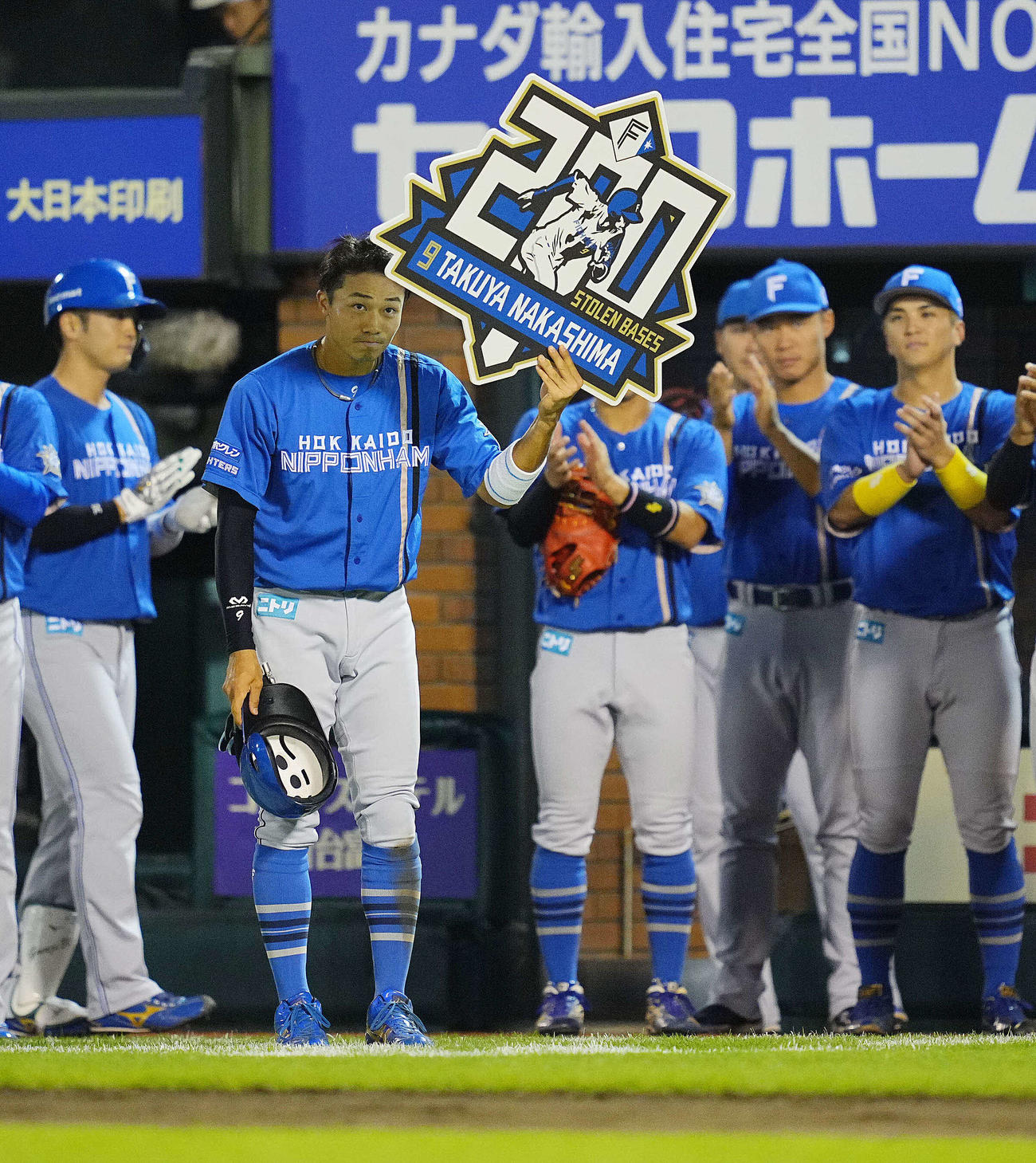 楽天対日本ハム　2回表に通算200盗塁を達成した日本ハム中島（左から2人目）は記念ボードを手にナインやファンの拍手を受ける（撮影・垰建太）