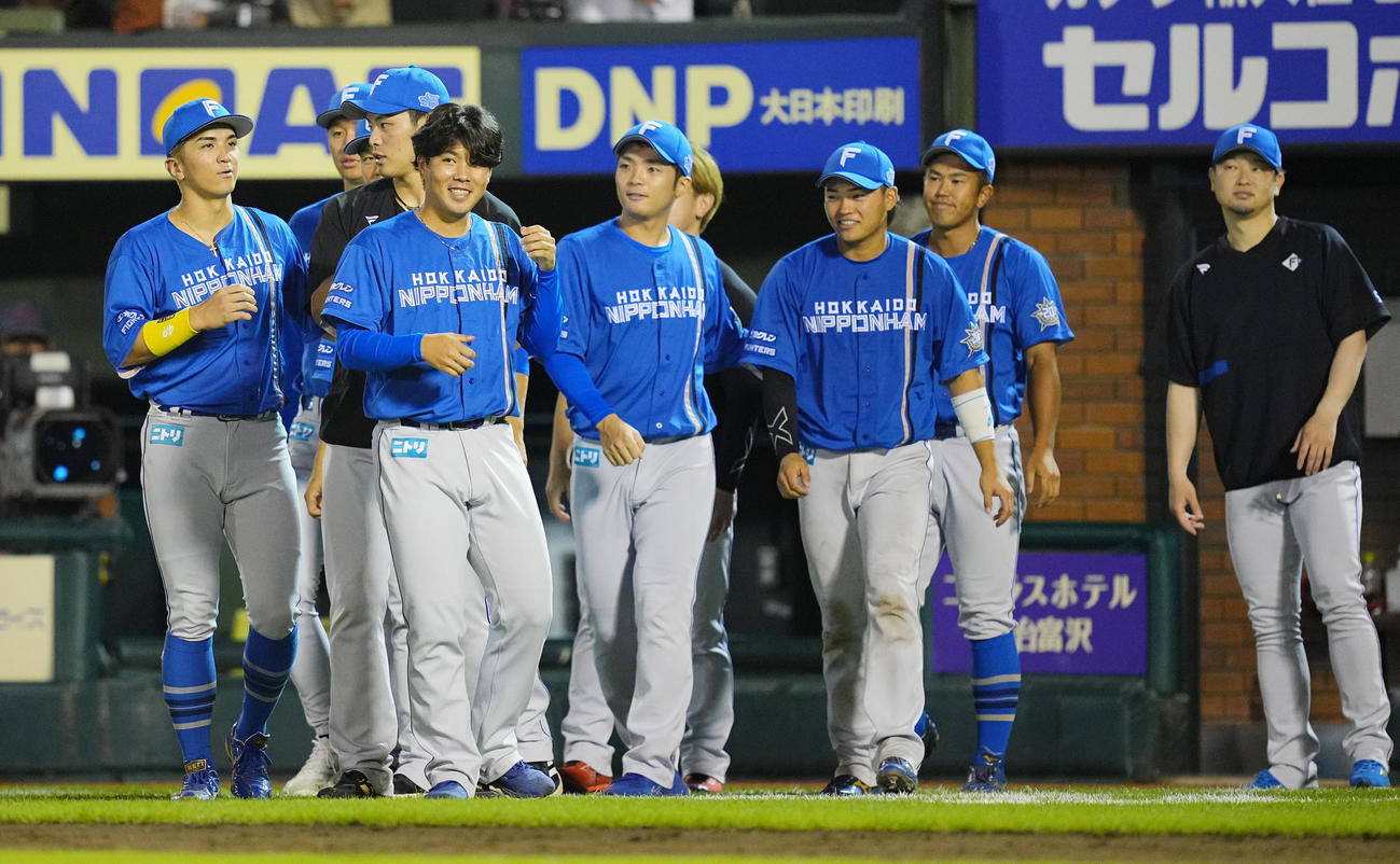 楽天対日本ハム　楽天に勝利しナインと笑顔で出迎えに向かう日本ハム金村（左か4人目）（撮影・垰建太）