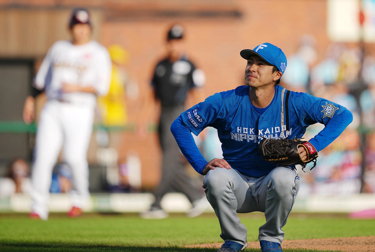 楽天対日本ハム　6回裏楽天2死二、三塁、辰己に適時内野安打を許し思わず苦笑いを浮かべしゃがみ込む上沢（撮影・垰建太）