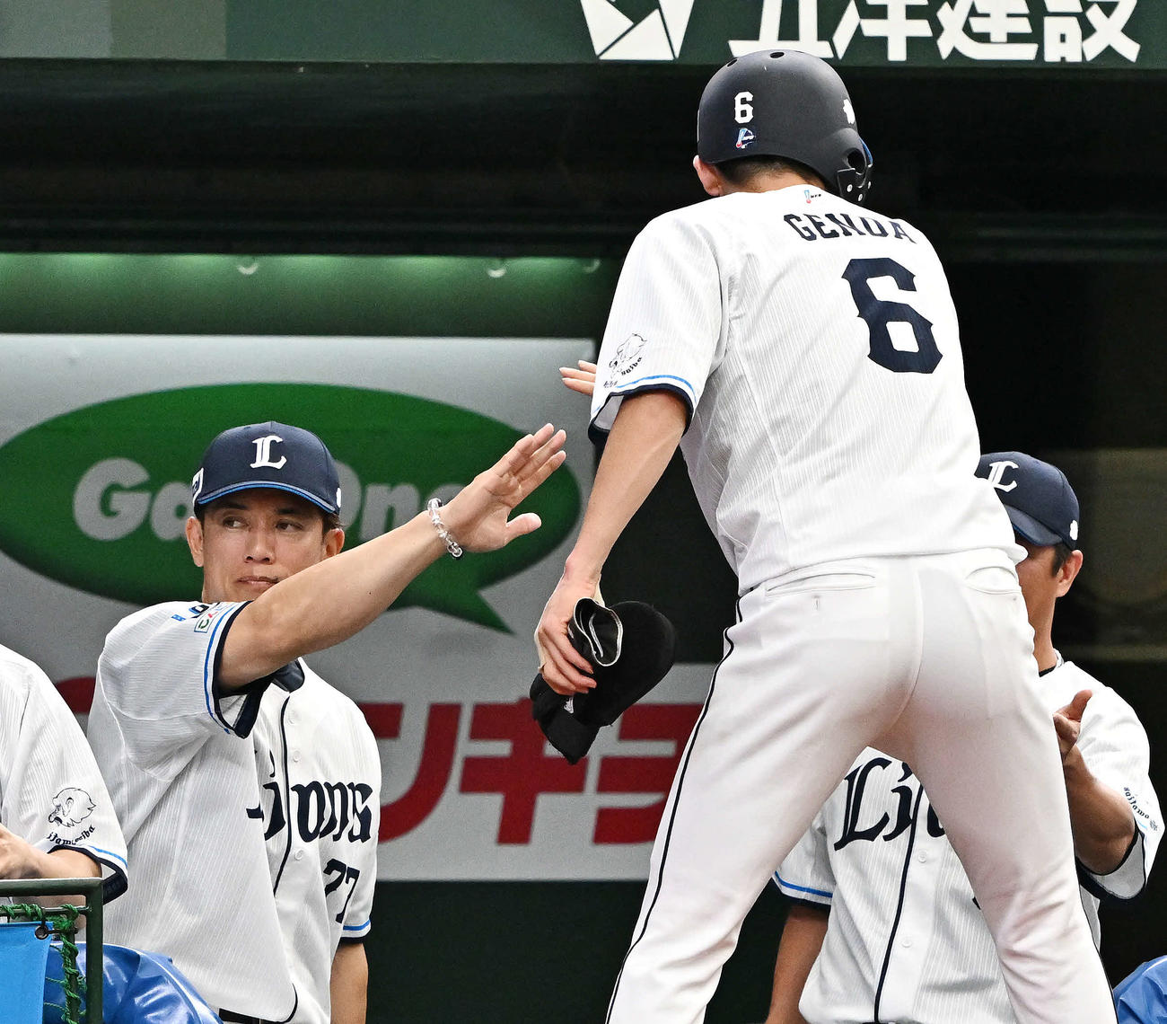 西武対ロッテ　2回裏に先制適時打を放った西武源田（手前）とタッチをかわす松井監督（撮影・滝沢徹郎）