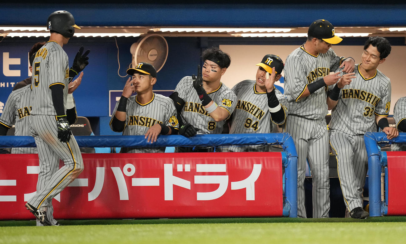 ヤクルト対阪神　1回表阪神無死二塁、中野の先制の右適時二塁打で生還した二塁走者近本（左）を迎える佐藤輝（中央）らベンチ（撮影・鈴木みどり）