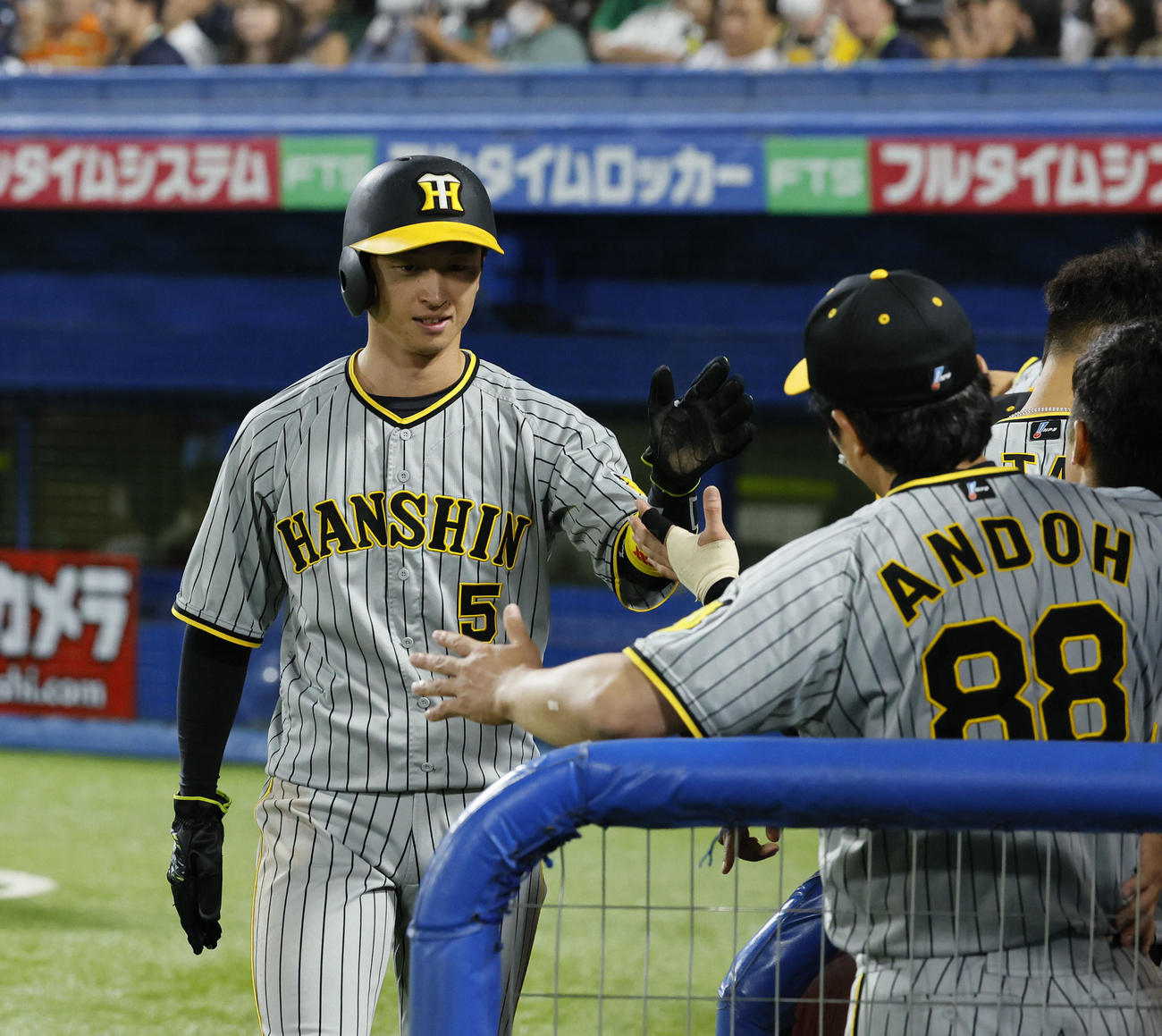 ヤクルト対阪神　1回表阪神無死二塁、中野の適時二塁打で生還し、ナインとタッチを交わす近本（撮影・藤尾明華）