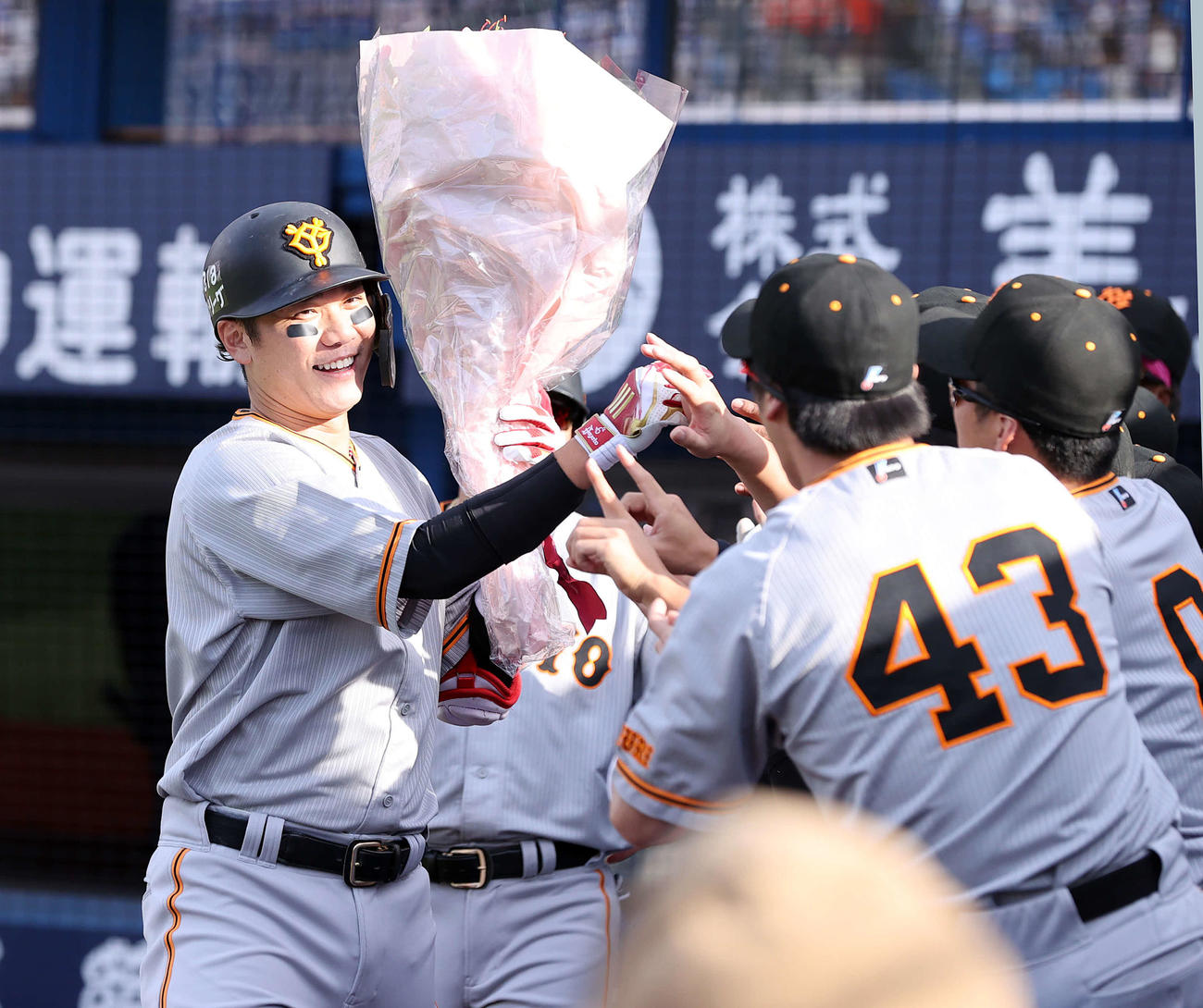 DeNA対巨人　5回表巨人1死三塁、坂本は左越え2点本塁打で1000打点を達成し、花束を手に笑顔でナインとハイタッチ（撮影・浅見桂子）