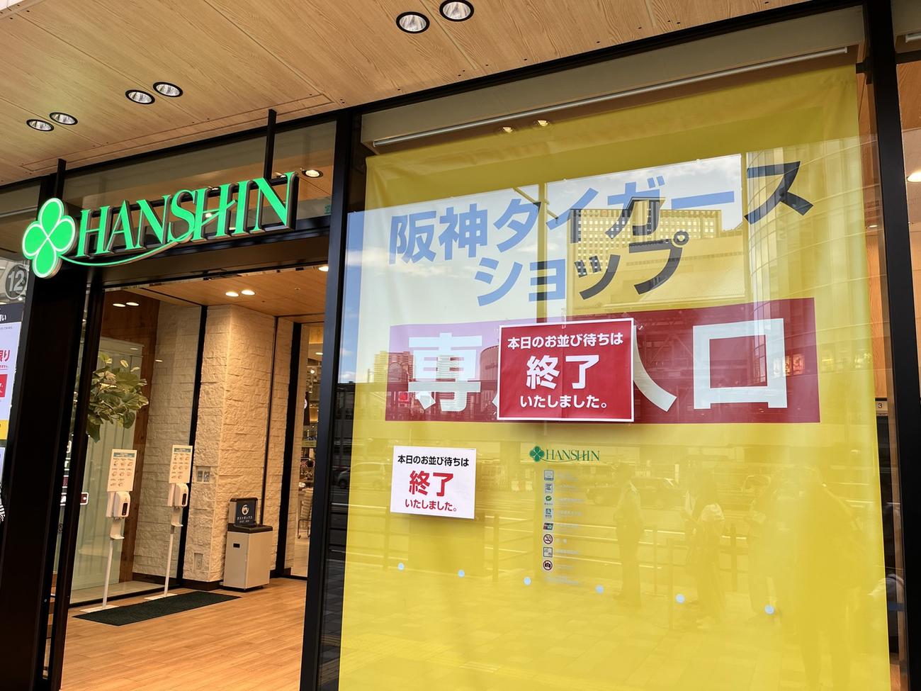 阪神のリーグ優勝記念グッズを買い求めるファンでにぎわう阪神百貨店梅田本店。「本日のお並び待ちは終了いたしました」という表示も（撮影・中野椋）