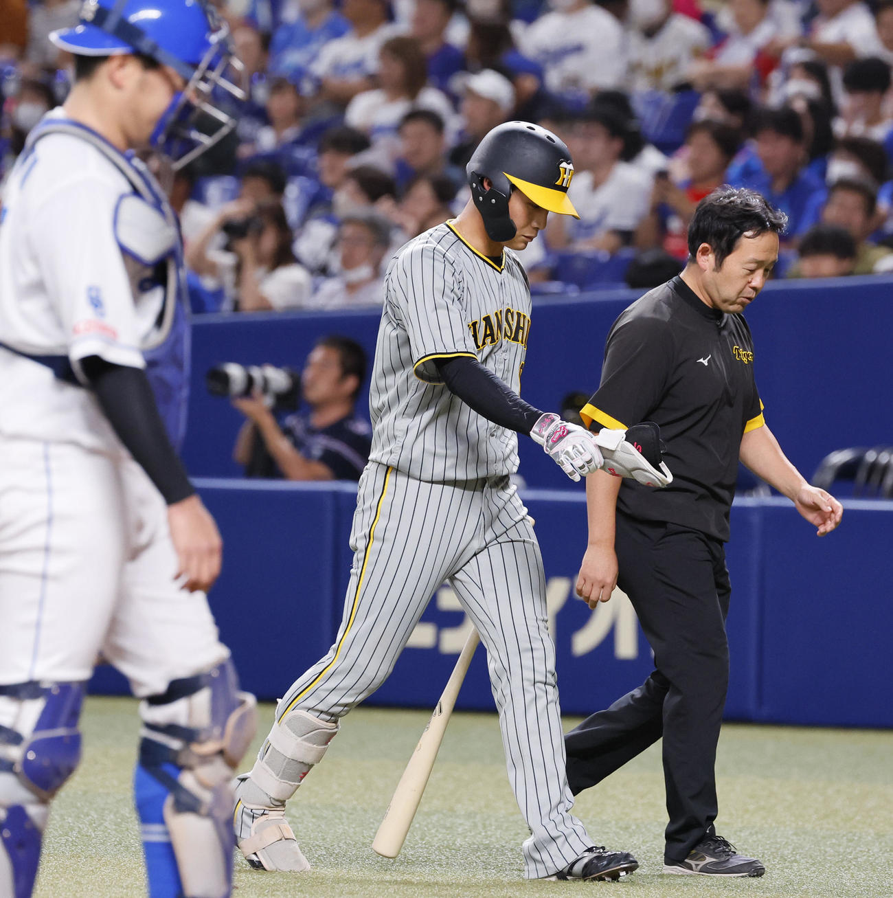 中日対阪神　11回表阪神無死、死球を受け交代する阪神木浪（中央）（撮影・藤尾明華）