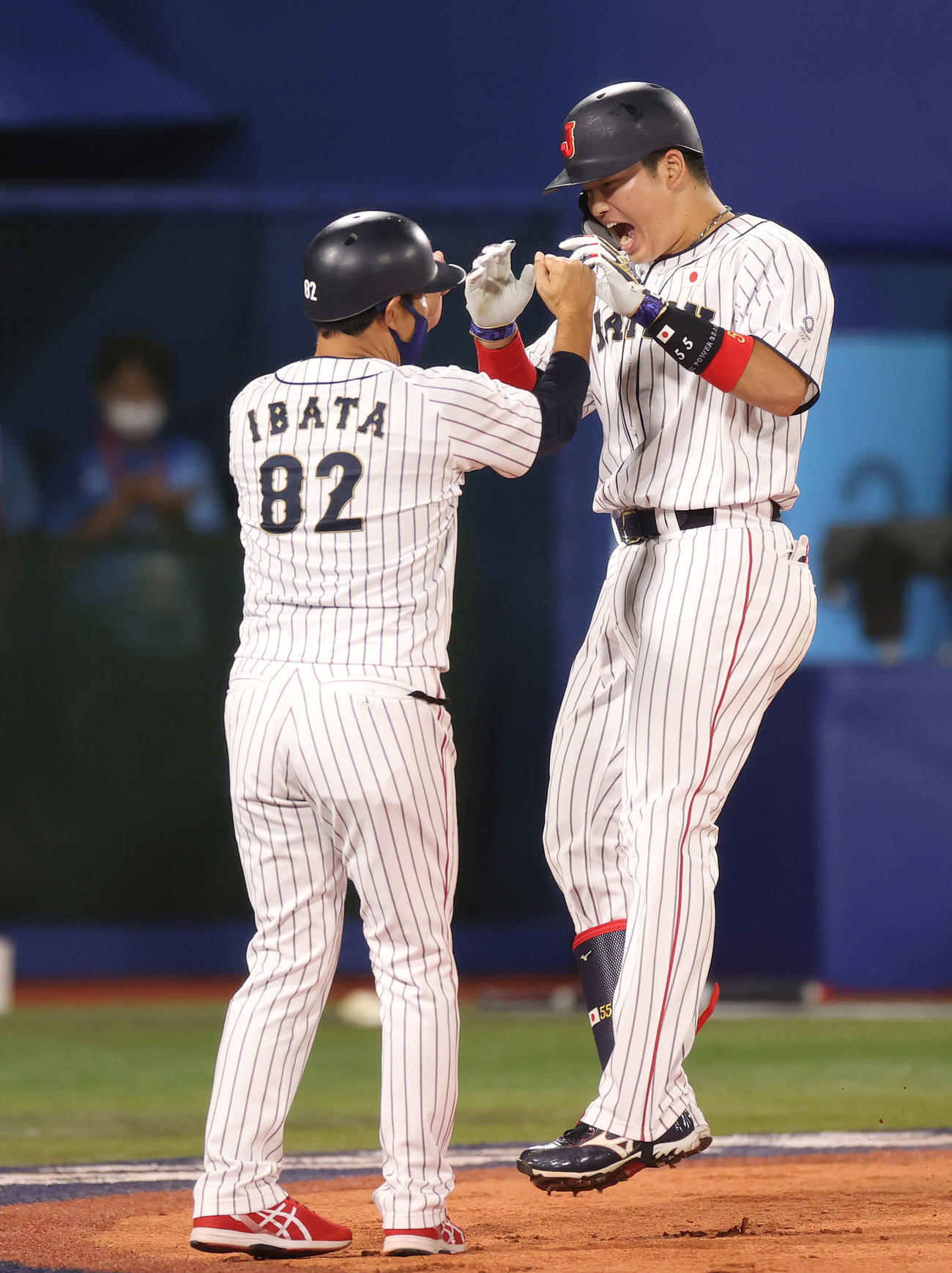 2021年8月7日、決勝の米国戦で3回裏日本1死、先制本塁打を放ち井端コーチ（左）に迎えられる村上