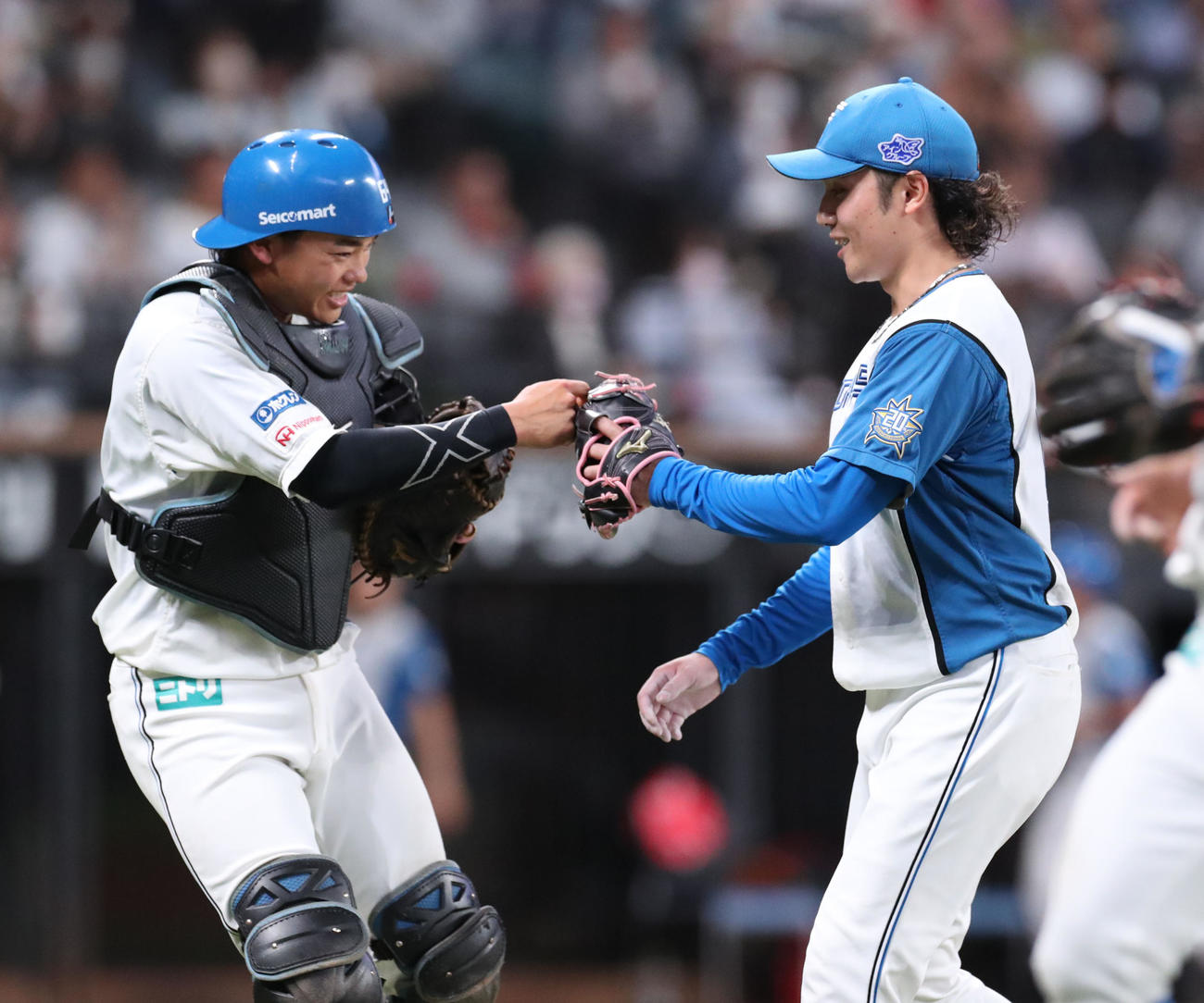 日本ハム対楽天　4回表楽天2死一塁、小深田の盗塁を阻止しグータッチをする田宮（左）と伊藤（撮影・佐藤翔太）