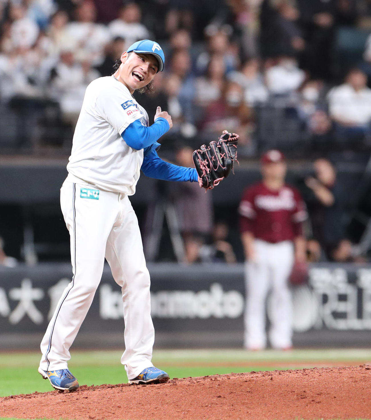 日本ハム対楽天　5回表楽天2死満塁、浅村を遊ゴロに仕留めグラブをたたく伊藤。右後方は田中将（撮影・佐藤翔太）