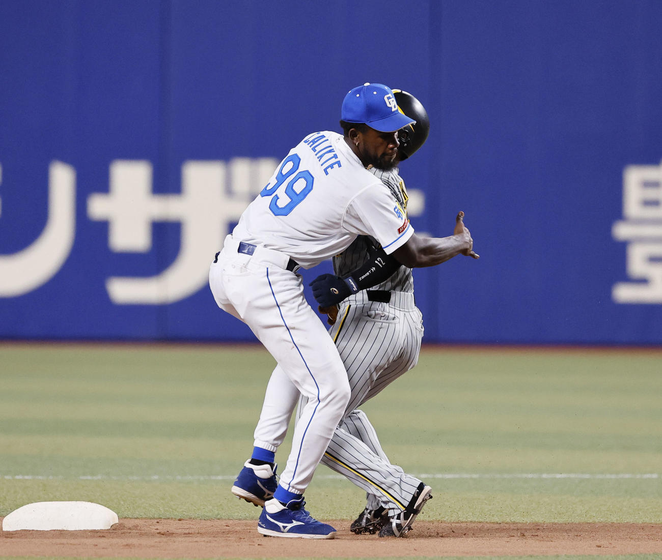 中日対阪神　2回表阪神1死一塁、木浪の一ゴロ併殺でぶつかりそうになり一走坂本を抱きしめる遊撃手カリステ（左）（撮影・藤尾明華）