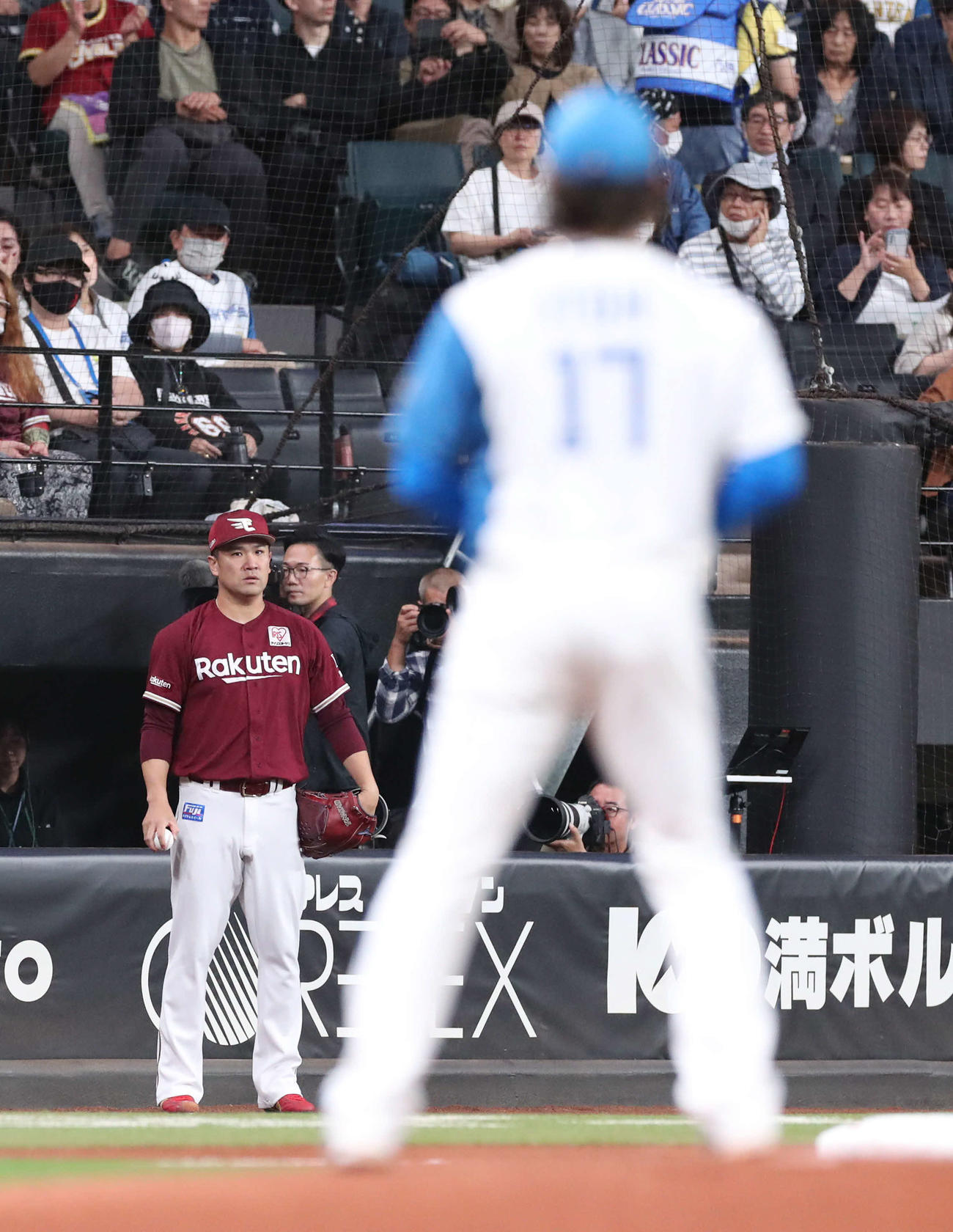 日本ハム対楽天　楽天田中将（後方）はキャッチボールの手を止めて、マウンドの日本ハム伊藤を見つめる（撮影・佐藤翔太）