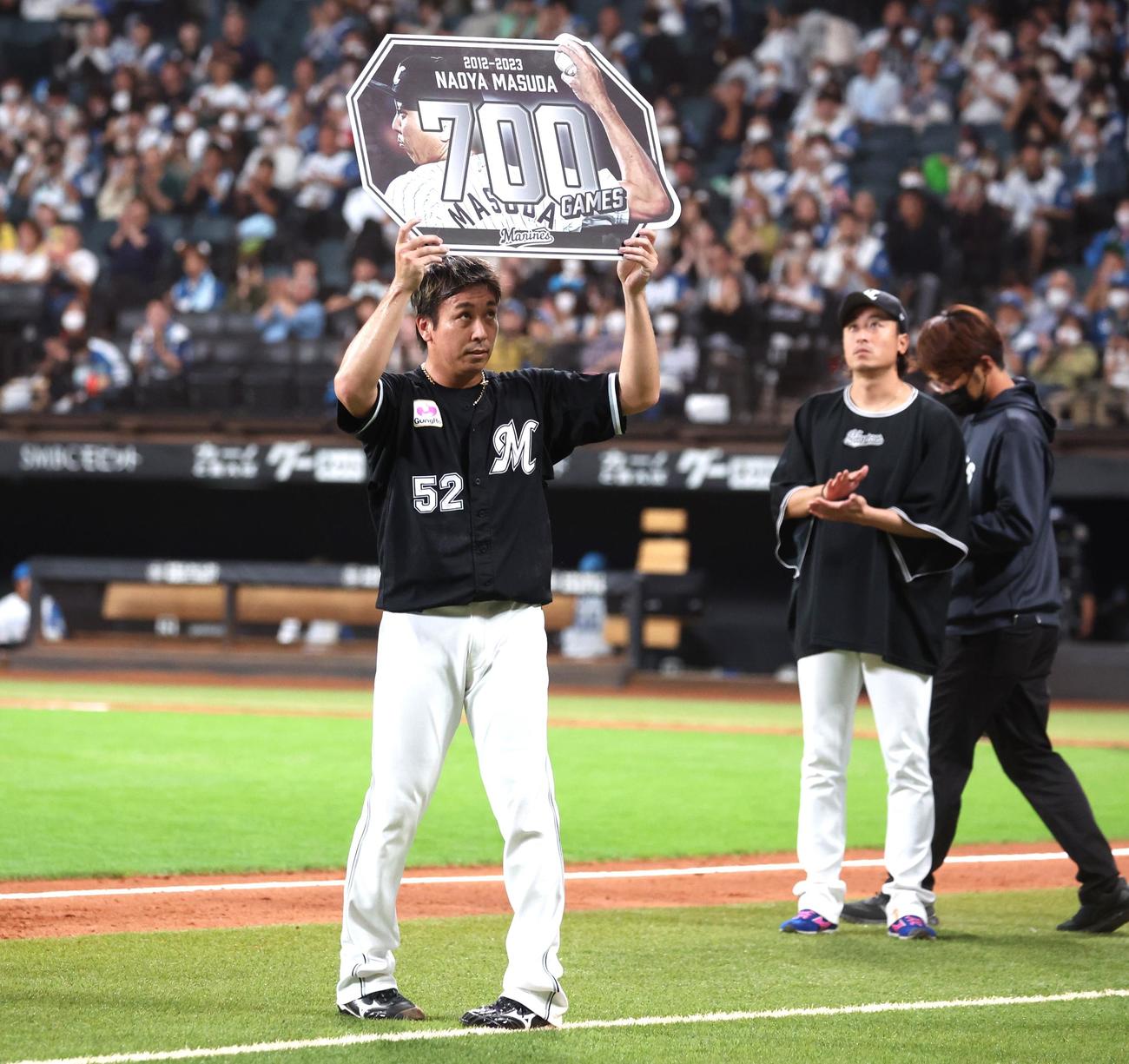 日本ハム対ロッテ　通算700試合登板を達成し記念ボードを掲げる益田（撮影・黒川智章）