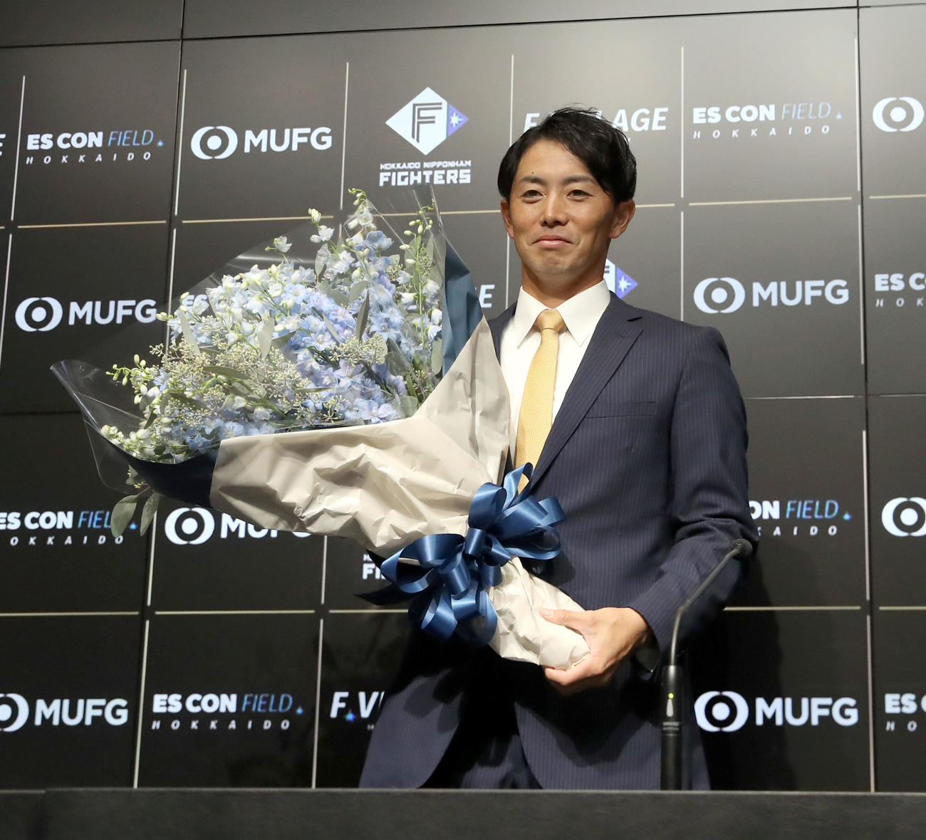 日本ハム対ロッテ　引退会見で花束を手に撮影に応じる日本ハム谷内（撮影・佐藤翔太）