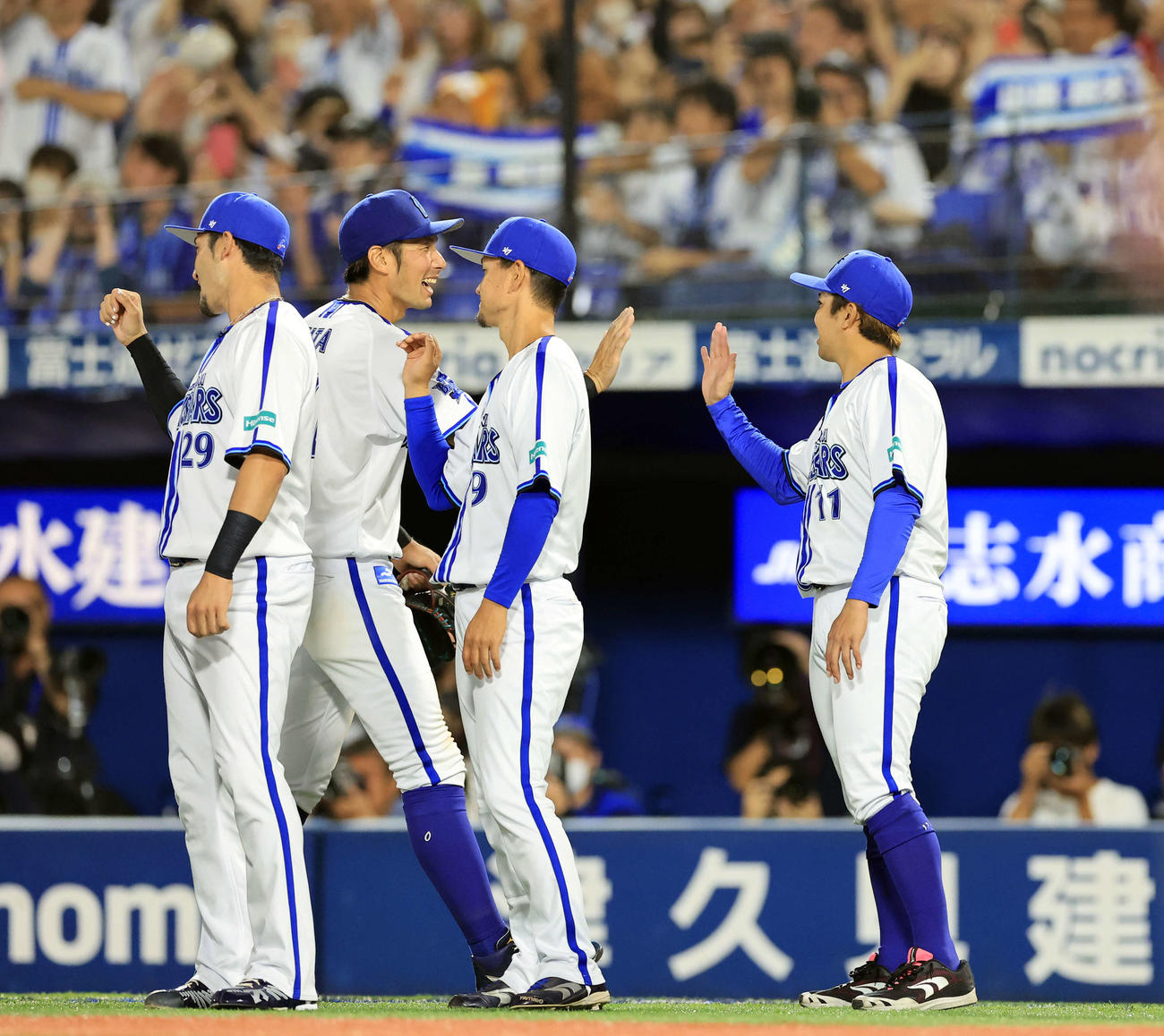 DeNA対巨人　16勝目を挙げたDeNA東（右）は大田らをハイタッチで迎える（撮影・浅見桂子）