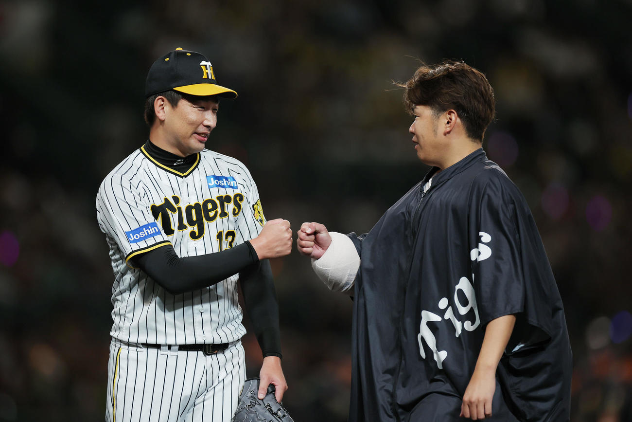 阪神対ヤクルト　ヤクルトに勝利し、グータッチを交わす阪神岩崎（左）と西勇（撮影・前田充）