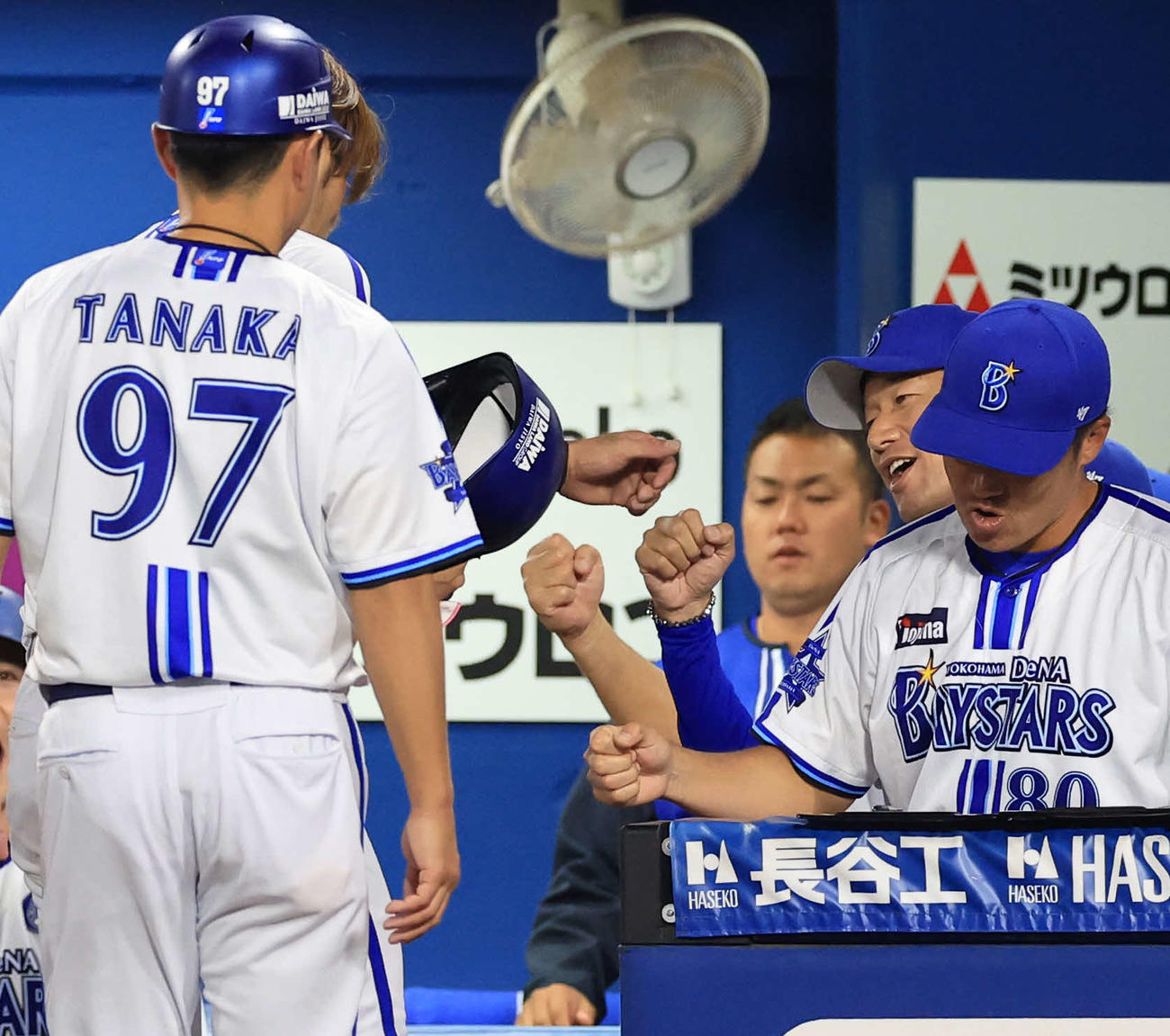 DeNA対巨人　3回裏DeNA2死三塁、先制左適時二塁打の大田（左奥）をグータッチで迎える三浦監督（右奥）（撮影・浅見桂子）