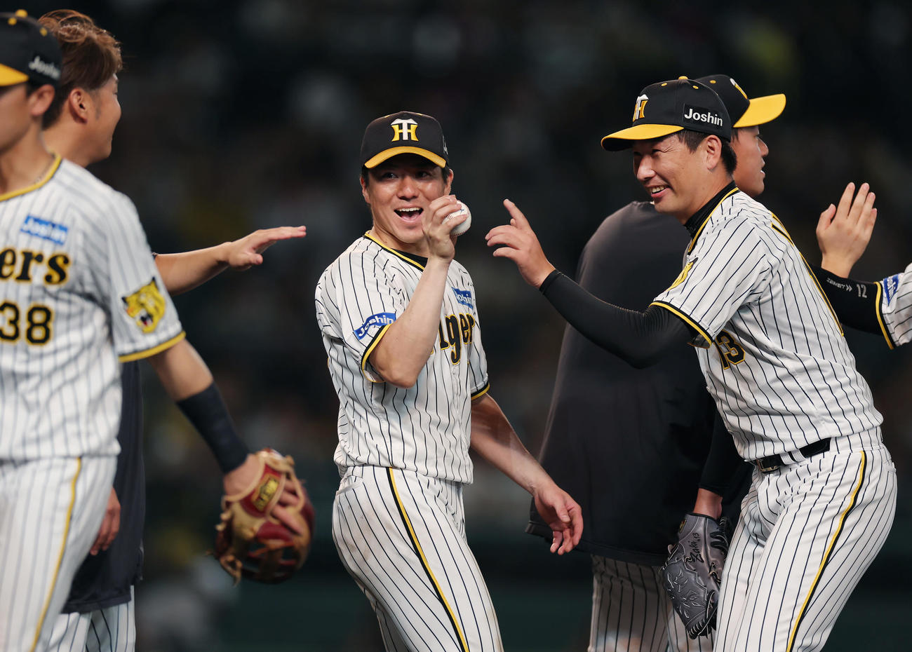 阪神対ヤクルト　ヤクルトに勝利し、阪神長坂（中央）へ勝利球を渡す岩崎。左は西勇（撮影・前田充）
