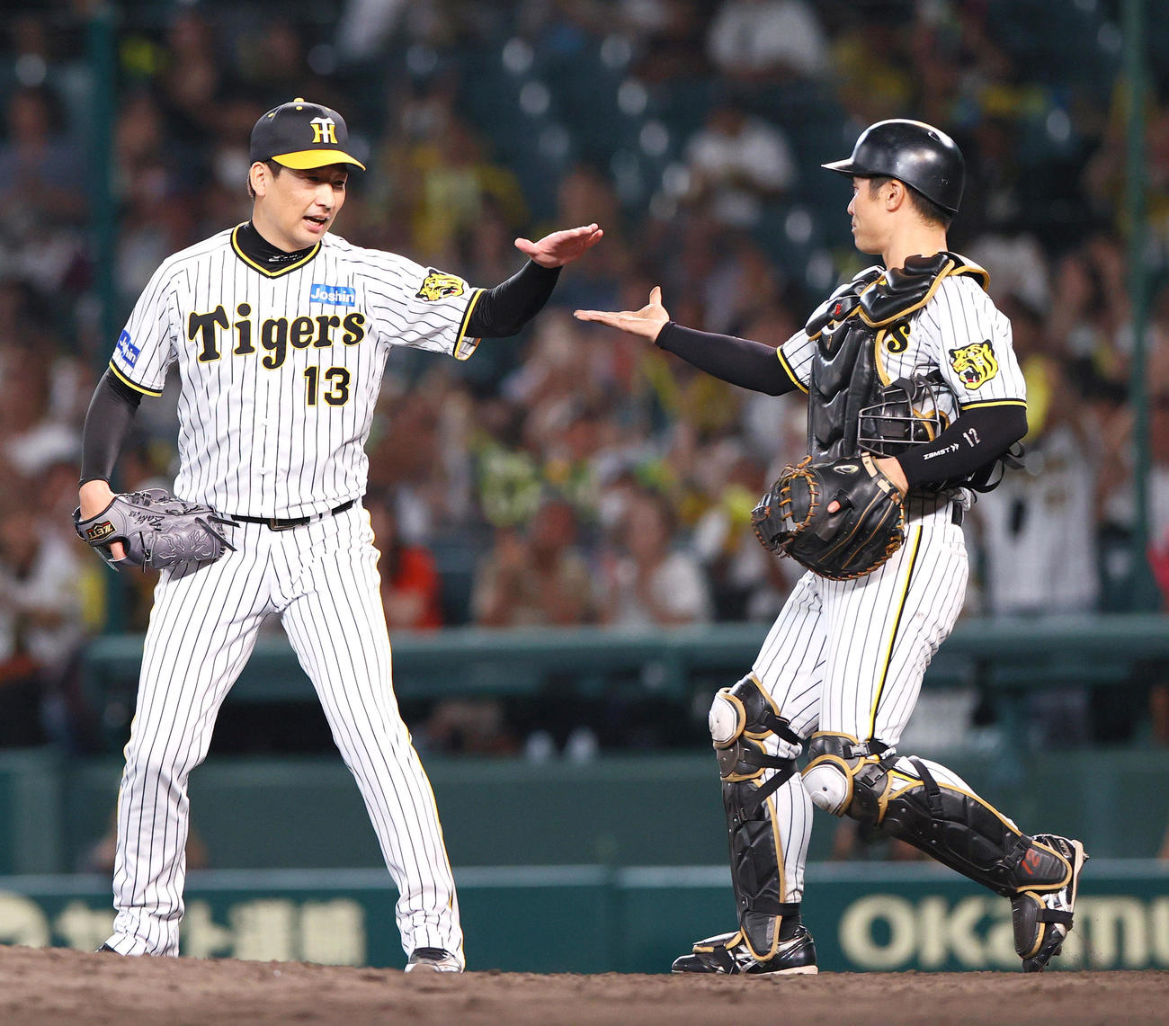 阪神対ヤクルト　試合を締めた阪神岩崎（左）は坂本とタッチをかわす（撮影・上山淳一）