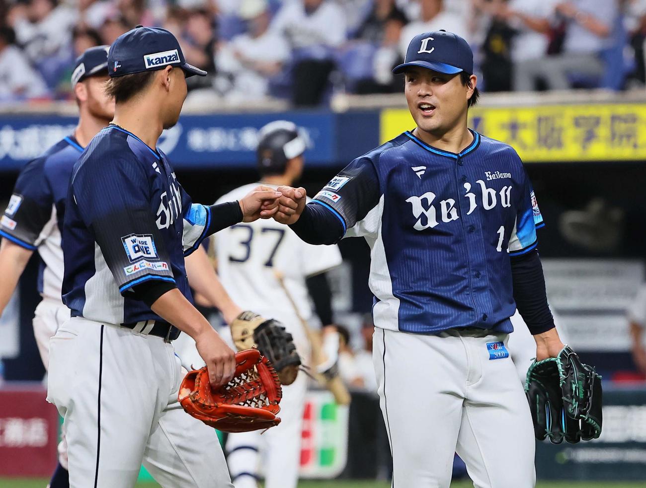 オリックス対西武　6回裏オリックス2死一、三塁、広岡を挟殺した松本（右）は佐藤とグータッチをする（撮影・上田博志）