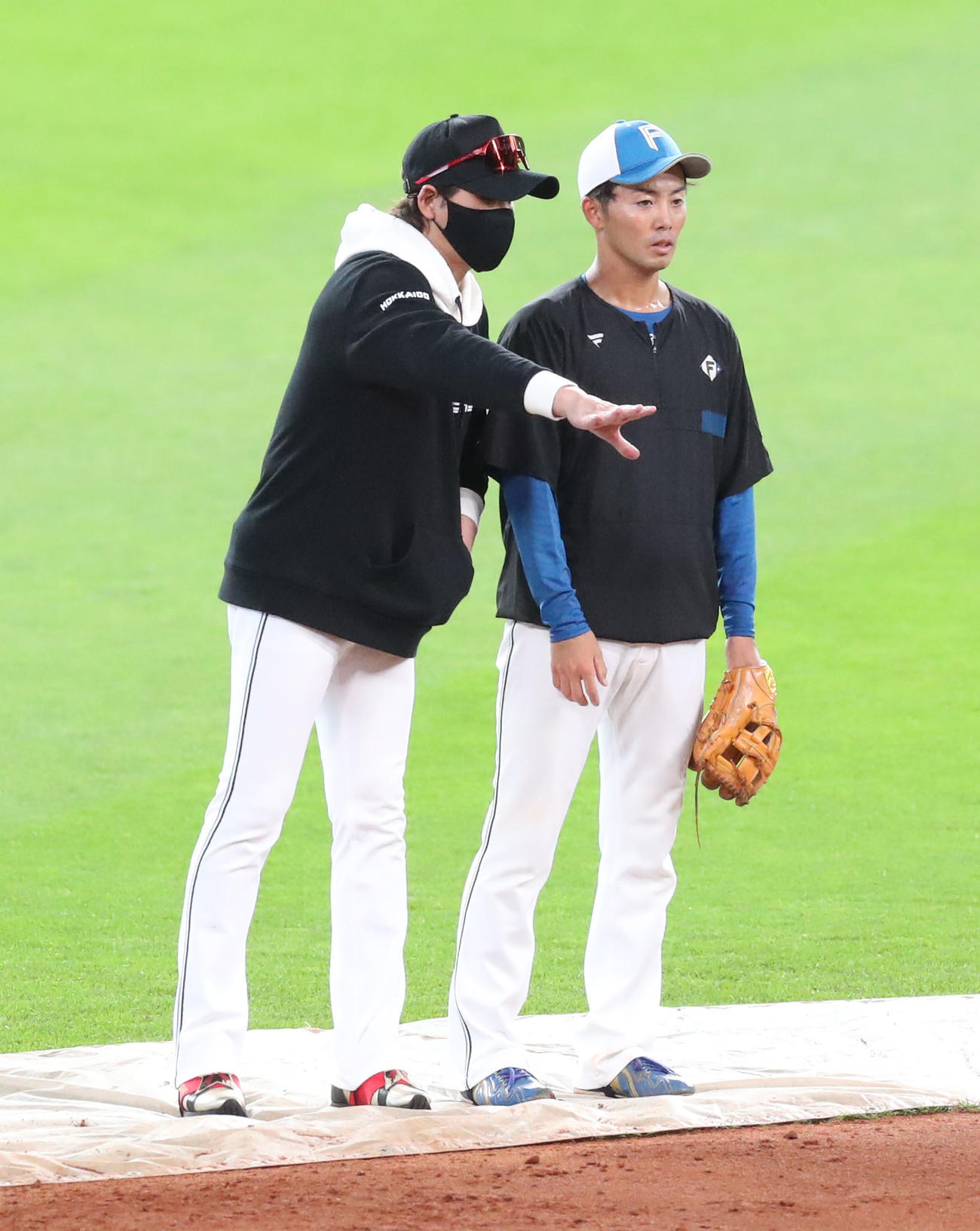 日本ハム対ロッテ　試合前、会話をする日本ハム新庄監督（左）と谷内（撮影・佐藤翔太）