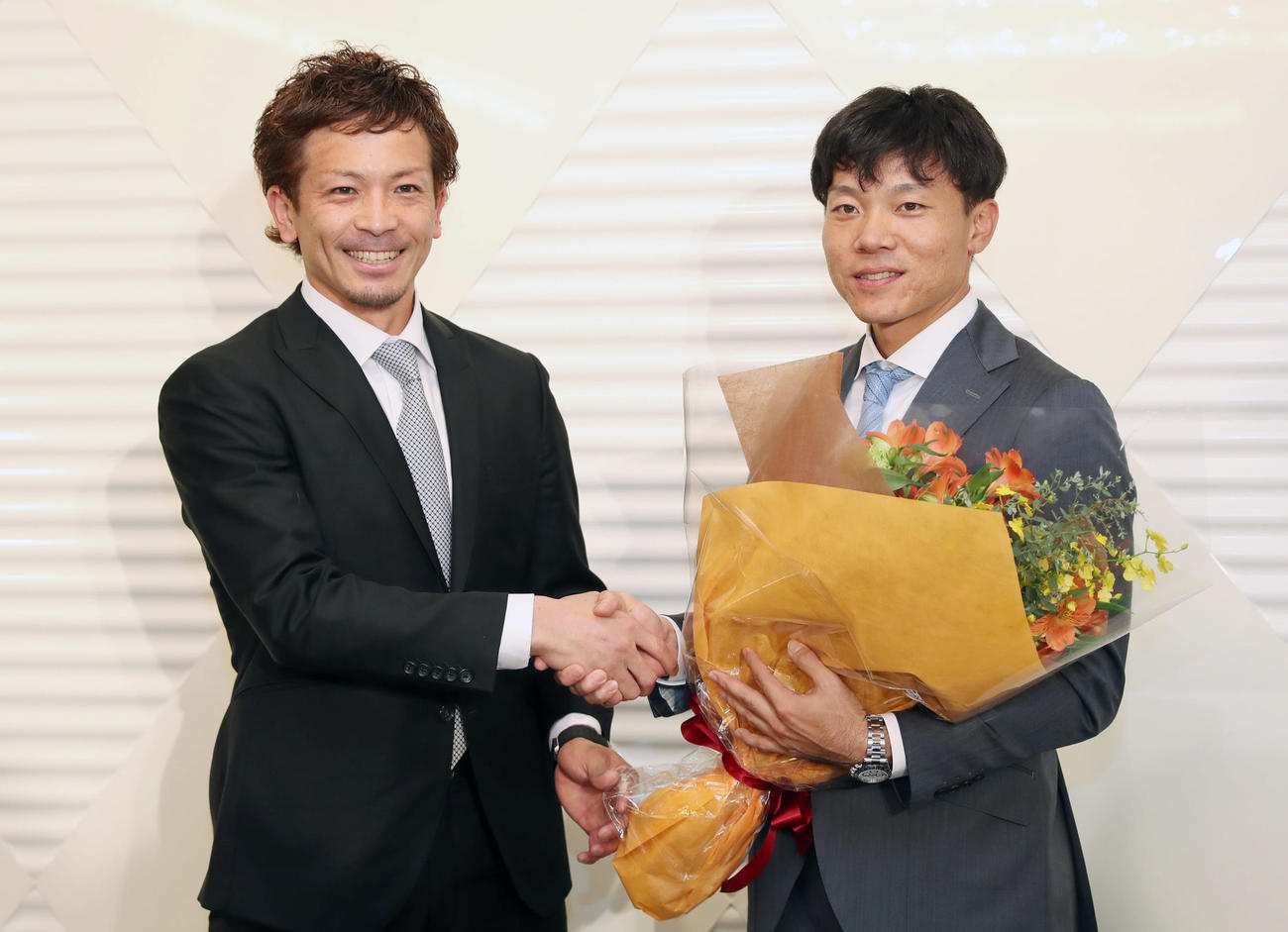 2019年12月、日本プロ野球選手会の前理事長を務めた中日大島（右）に花束を贈り握手を交わす、新理事長のソフトバンク松田宣浩