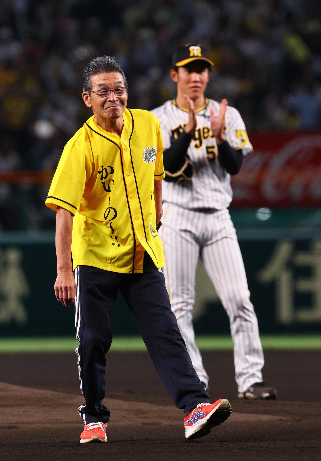 阪神対中日　始球式で投球を終え、笑顔を見せる間寛平。奥は阪神富田（撮影・上山淳一）
