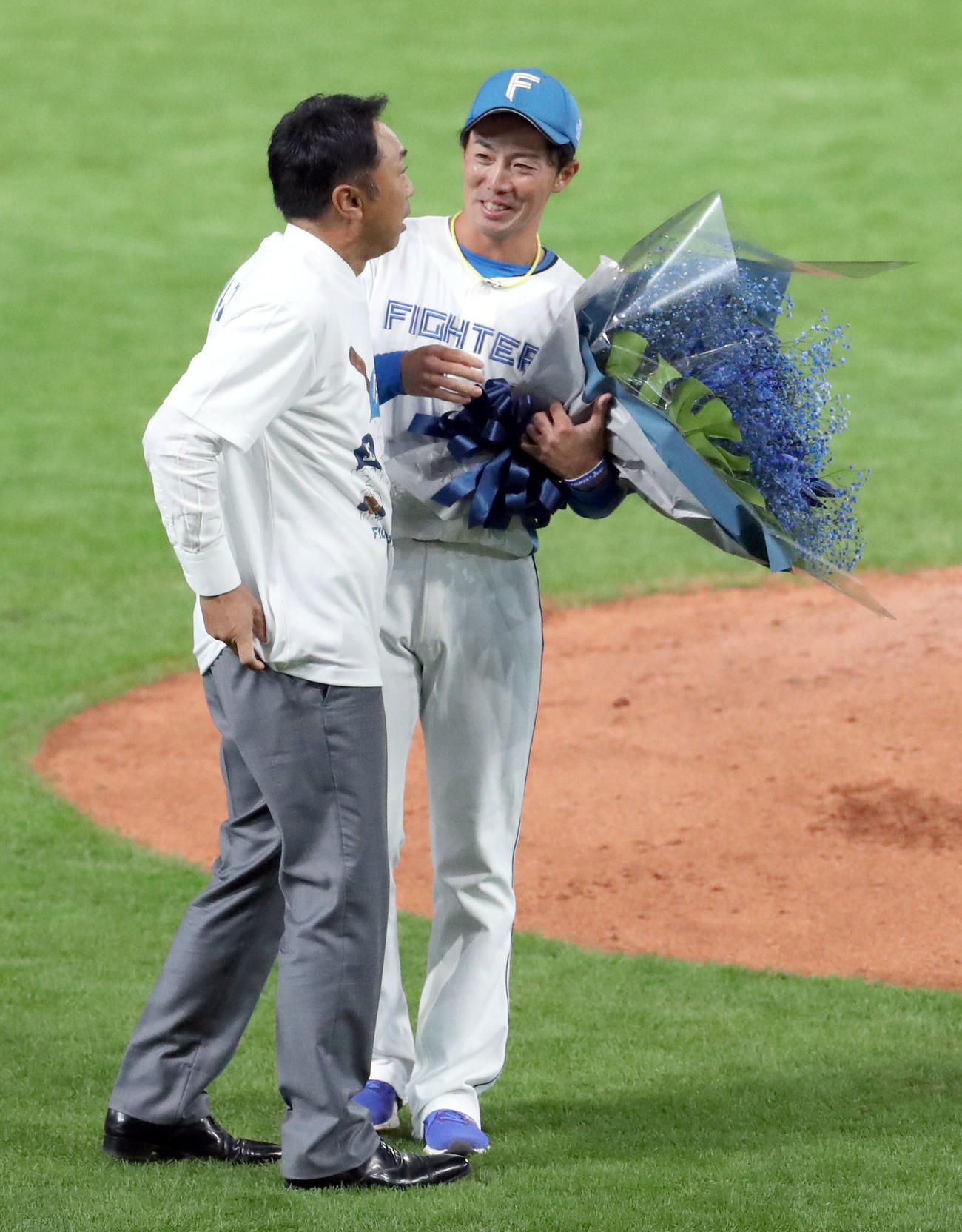 日本ハム対ロッテ　宮本氏からラストノックを受け花束を手渡される日本ハム谷内（撮影・佐藤翔太）