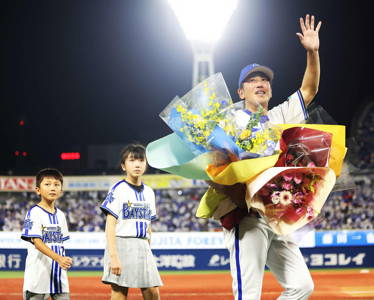 DeNA対ヤクルト　引退セレモニーであいさつを終え、花束を手に子どもたちと場内一周するDeNA藤田（撮影・河田真司）