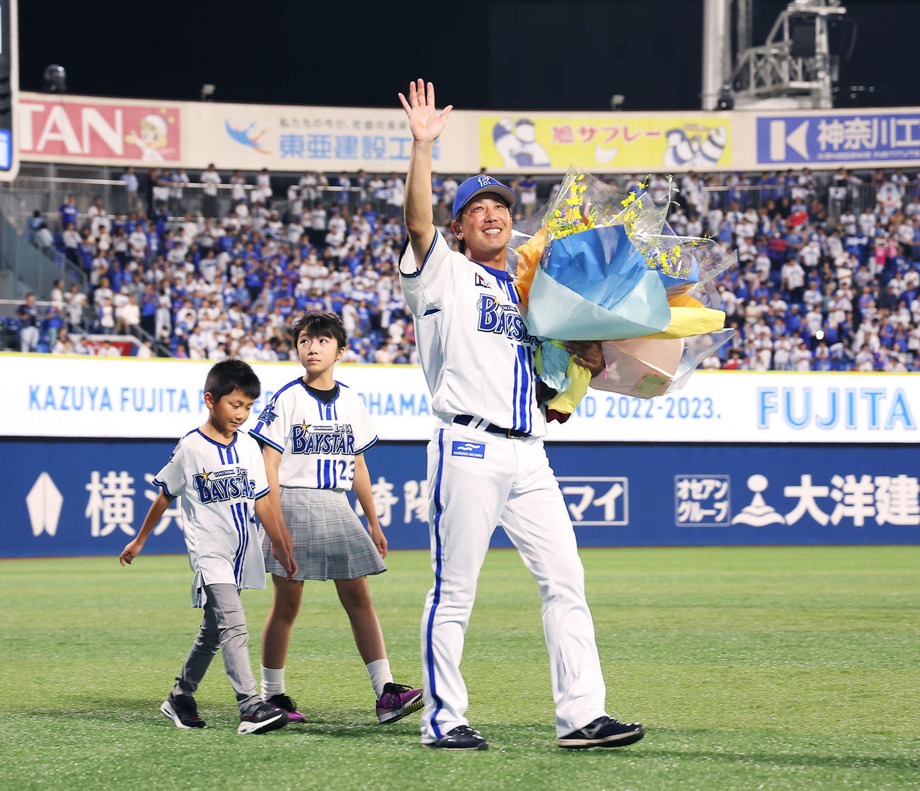DeNA対ヤクルト　引退セレモニーであいさつを終え、花束を手に子どもたちと場内一周するDeNA藤田（撮影・河田真司）