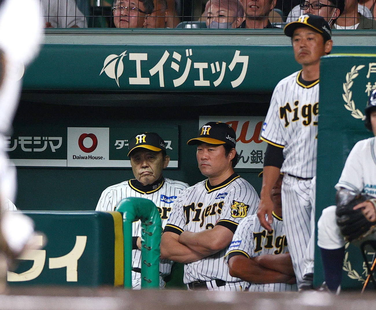 阪神対中日　7回表中日1死一、二塁、岡田監督（左）は西純が石川昂に左適時二塁打を浴びベンチで厳しい表情を見せる（撮影・上山淳一）
