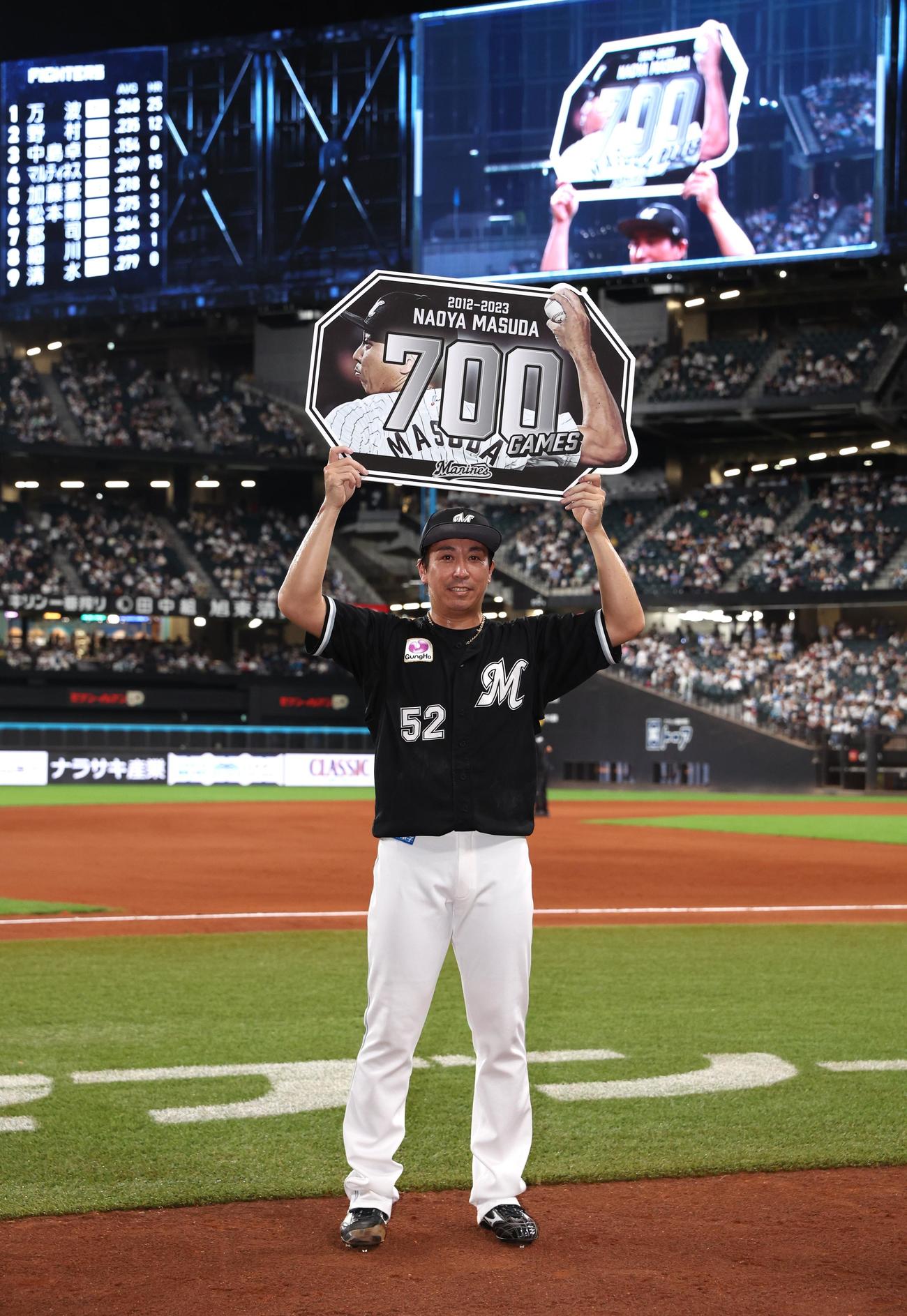 日本ハム対ロッテ　通算700試合登板を達成し記念ボードを掲げる益田（撮影・黒川智章）