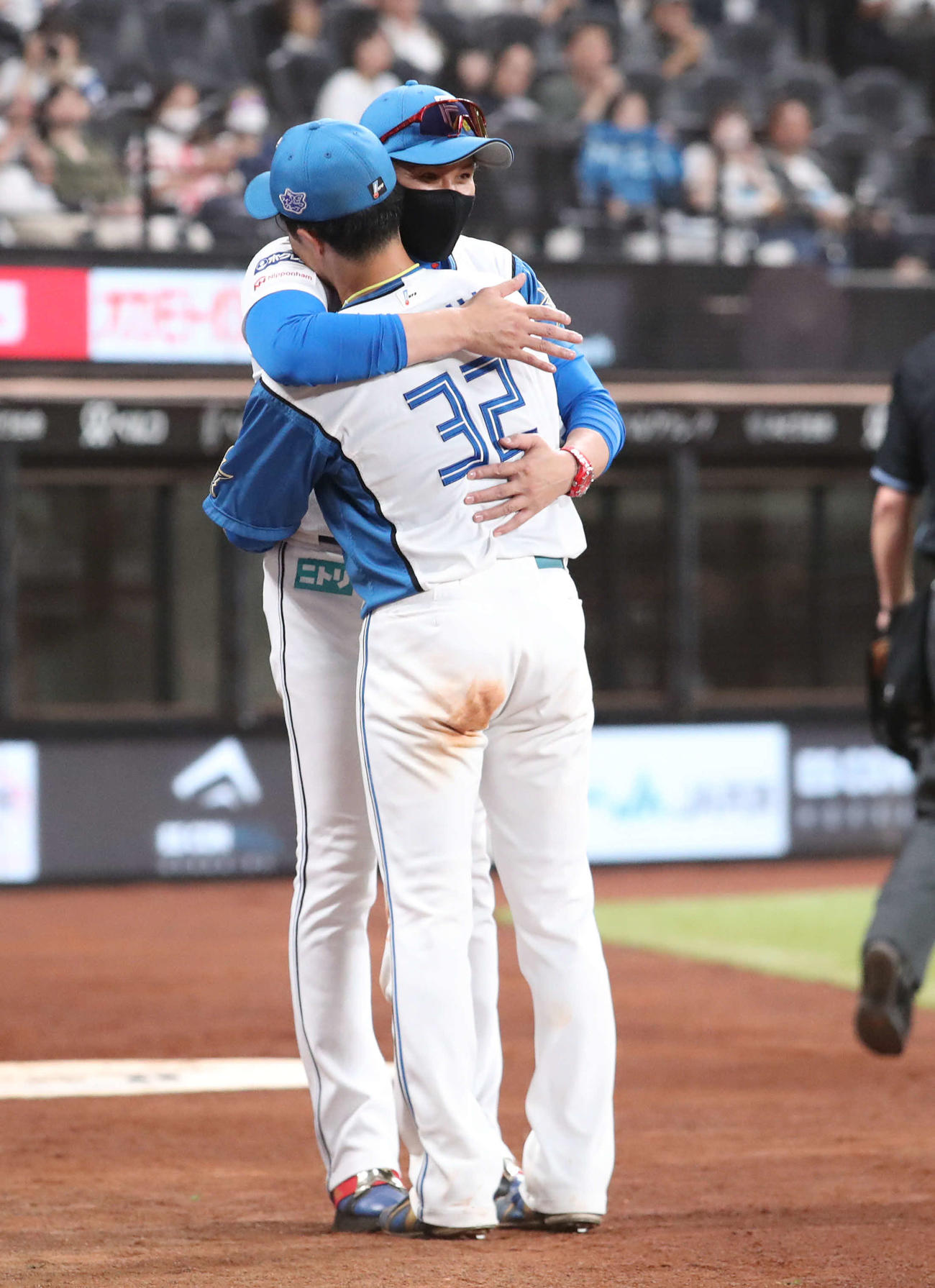 日本ハム対ロッテ　5回表、新庄監督（後方）は交代を告げた谷内を抱きしめる（撮影・佐藤翔太）