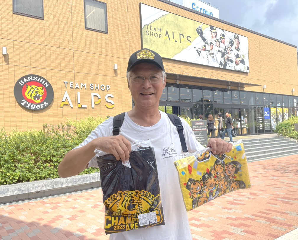 西宮市在住の70代虎党の男性は優勝グッズを手に喜んだ（撮影・中島麗）