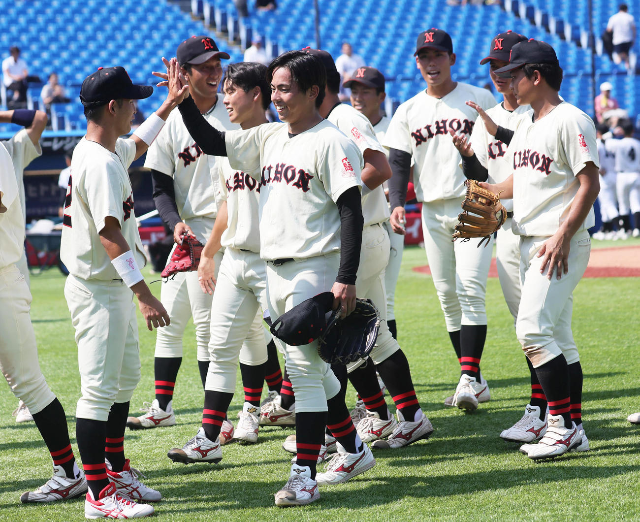 亜大対日大　勝利し、笑顔でタッチを交わす日大・山内翔（中央）ら（撮影・足立雅史）