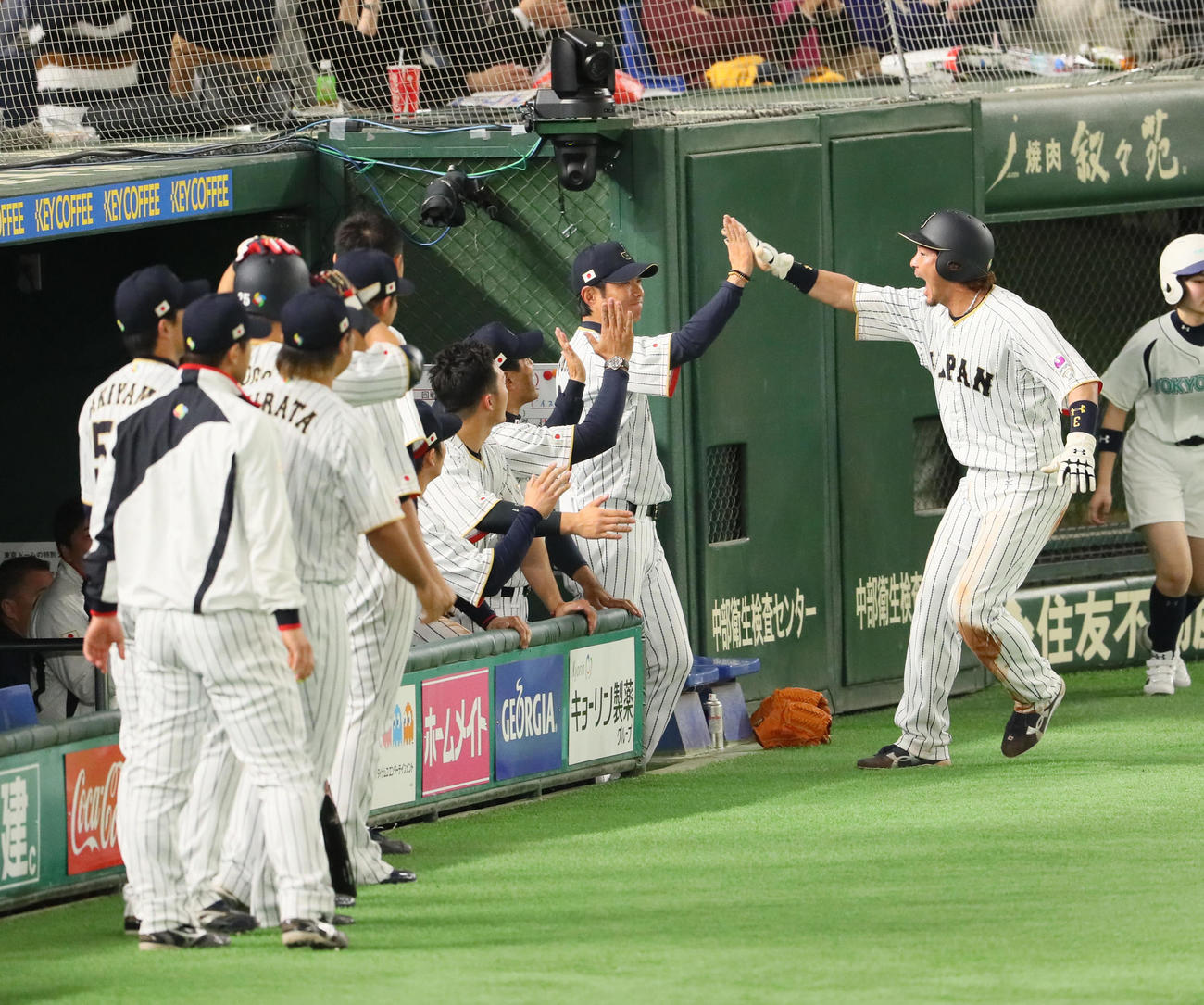 日本対イスラエル　6回裏日本1死満塁、菊池の右前適時打で生還した松田（右端）は小久保監督（同2人目）と笑顔でタッチを交わす（2017年3月15日撮影）