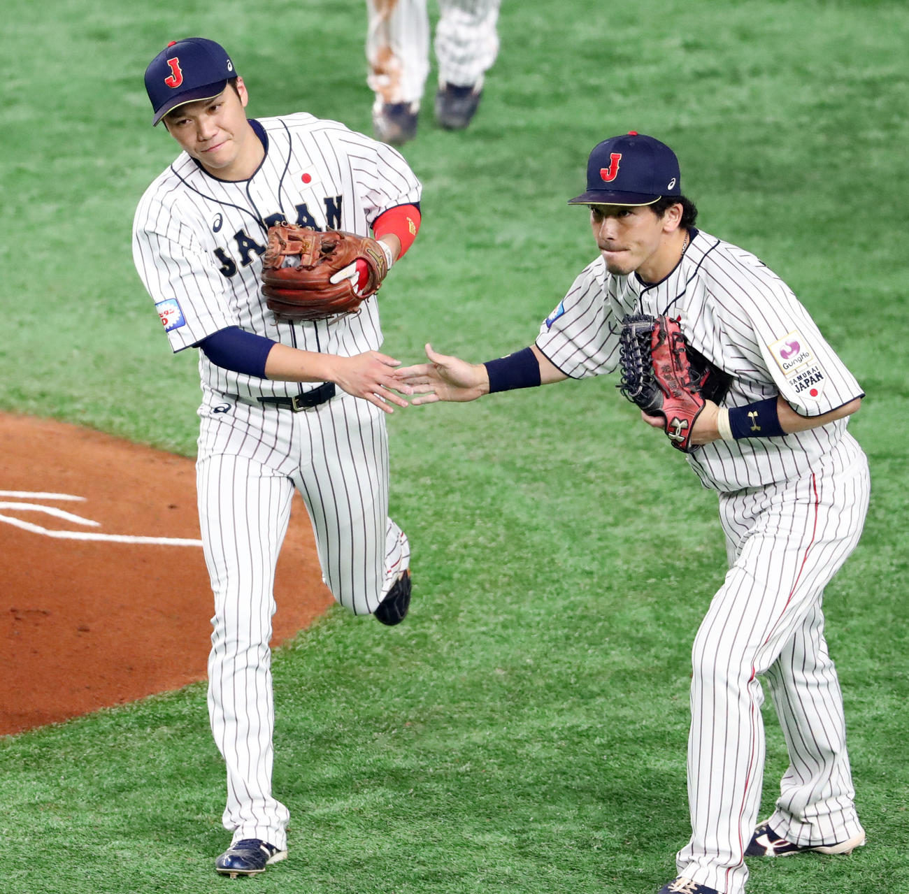 19年プレミア12、日本対メキシコ　坂本（左）は松田とタッチを交わす