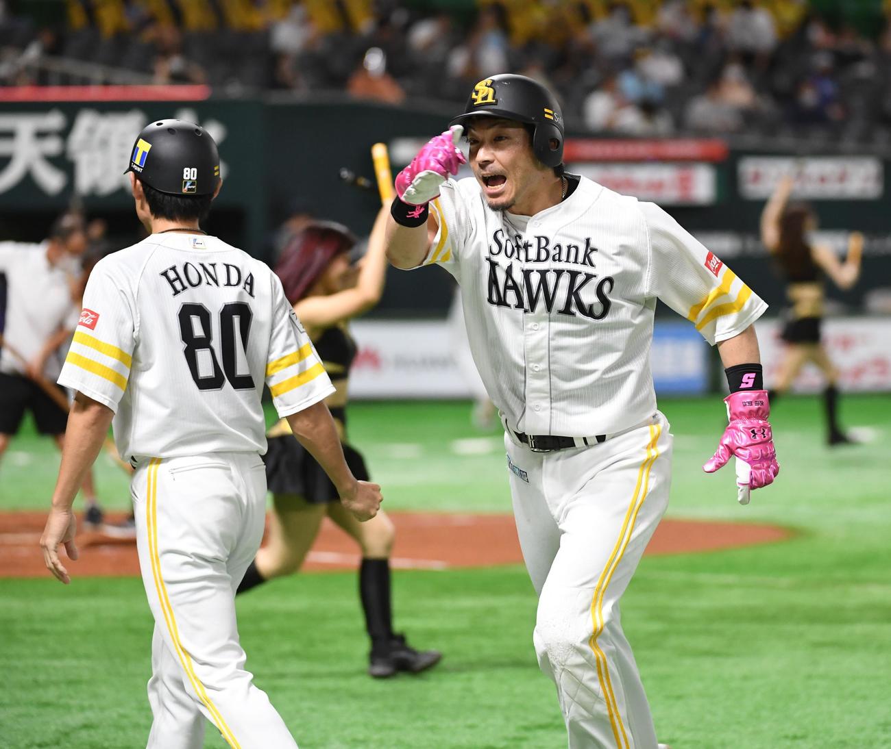 2020年8月12日、ソフトバンク対オリックス　5回裏に先制の2点適時打を放った松田宣（右）は本多コーチと笑顔でタッチする