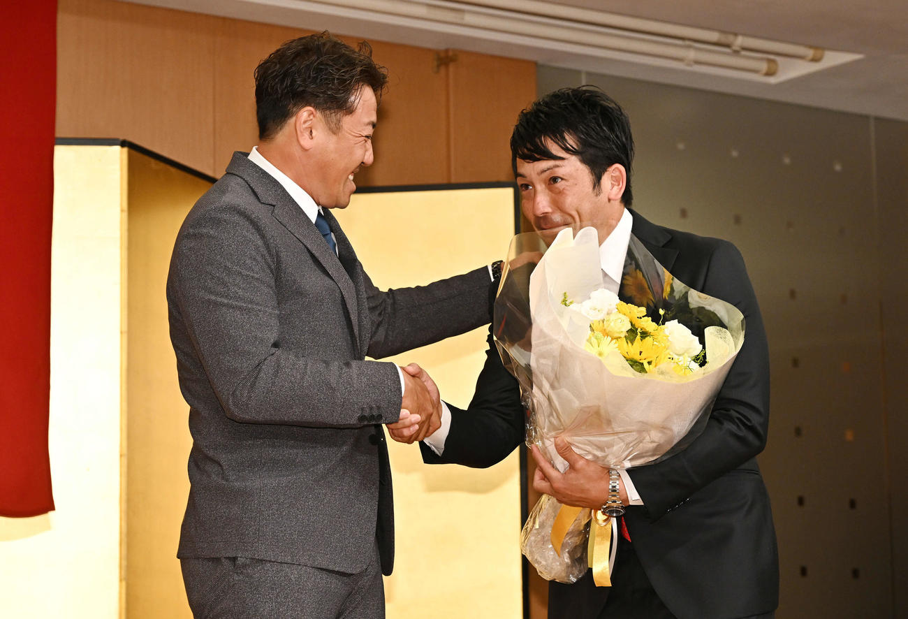 引退会見で巨人松田（右）はサプライズで登場した内川から花束を渡され涙を流す（撮影・滝沢徹郎）