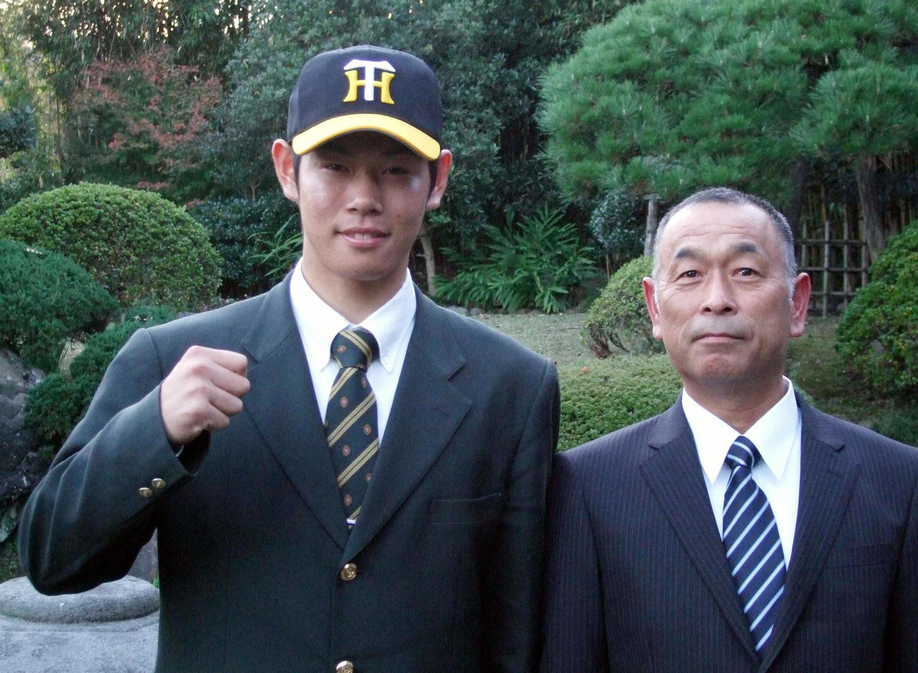 2009年11月18日、阪神と仮契約を済ませたドラフト6位原口（左）は、父秀一さんと記念撮影に納まる