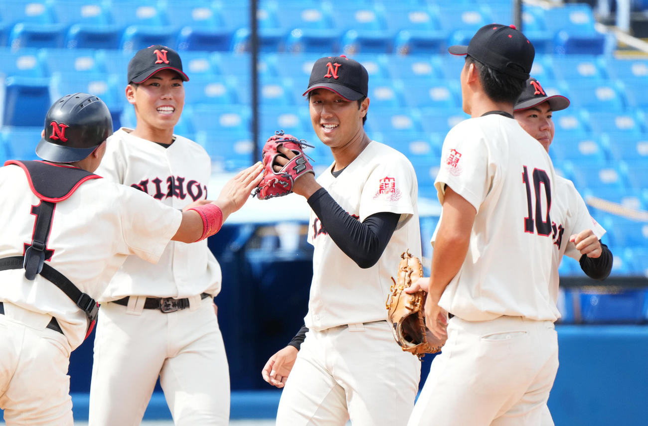亜大対日大　亜大に勝利し、ナインとタッチをする日大・市川（中央）（撮影・菅敏）