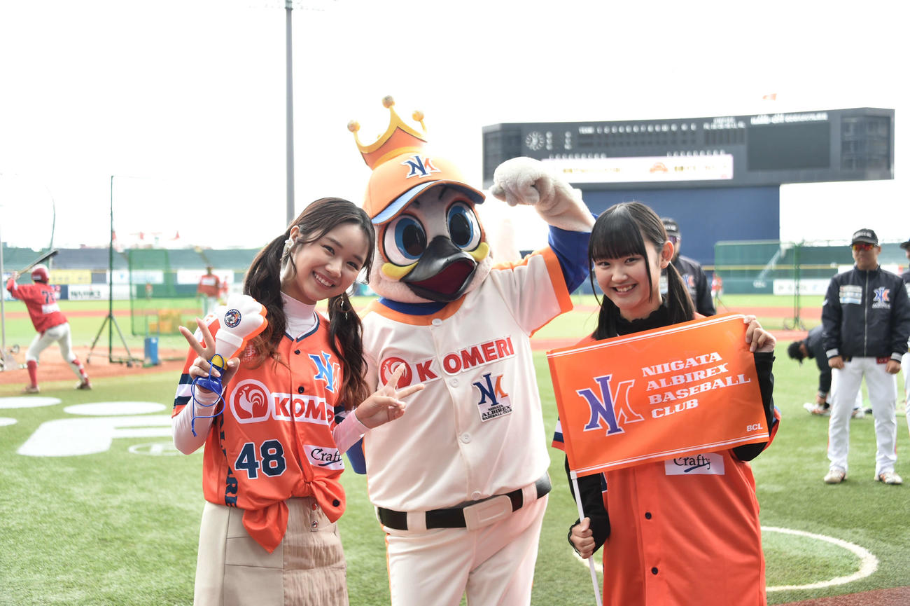 2023年4月9日　試合前、BC新潟のマスコット、アルファくんとともにチームにエールを送るNGT48の真下華穂（左）と磯部瑠紅