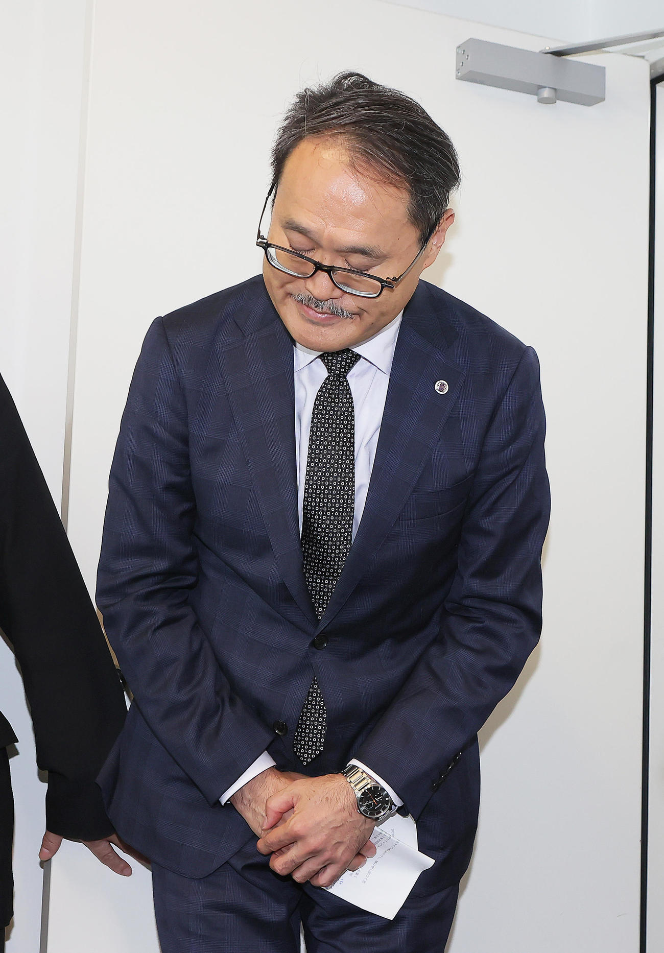 試合前、緊急の会見に臨み、頭を下げる立大の金子部長（撮影・足立雅史）