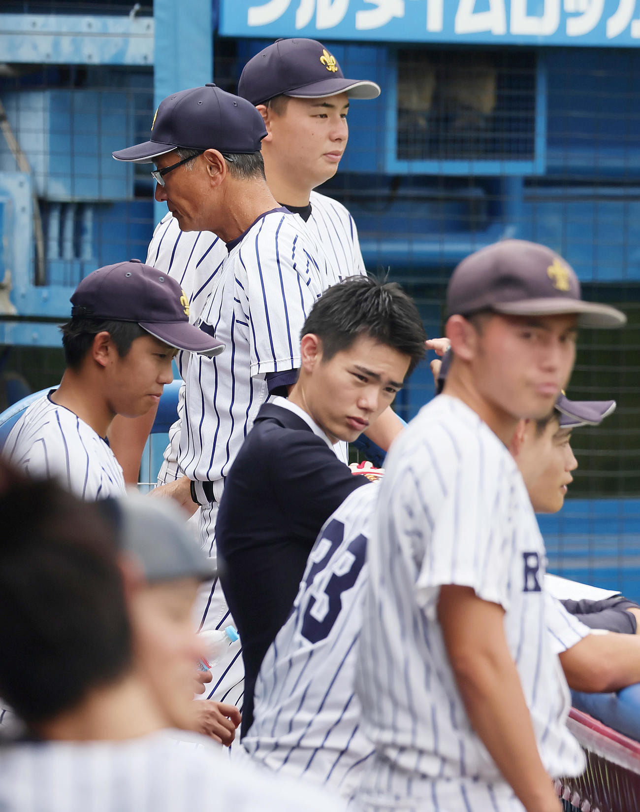 明大対立大　4回、投手交代を告げベンチに戻る立大・木村コーチ（後方左から2人目）（撮影・足立雅史）