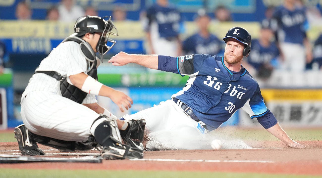 ロッテ対西武　2回表西武1死一、二塁、西川の先制の右前適時打で生還する二塁走者マキノン。捕手佐藤都（撮影・鈴木みどり）