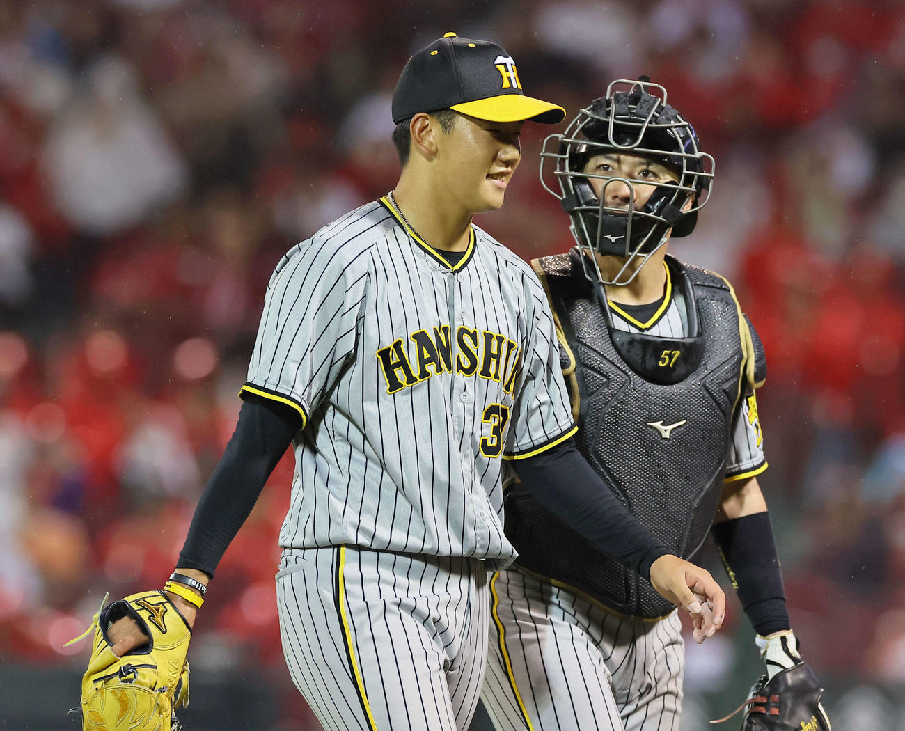 広島対阪神　好投する門別（左）は長坂と笑顔を見せながらベンチに引き揚げる（撮影・上田博志）