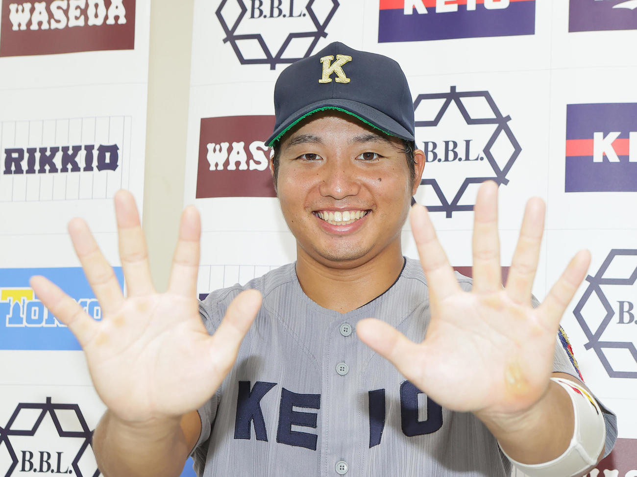 東大対慶大　5安打5打点の活躍を見せた慶大・栗林泰は笑顔でポーズを決める（撮影・足立雅史）