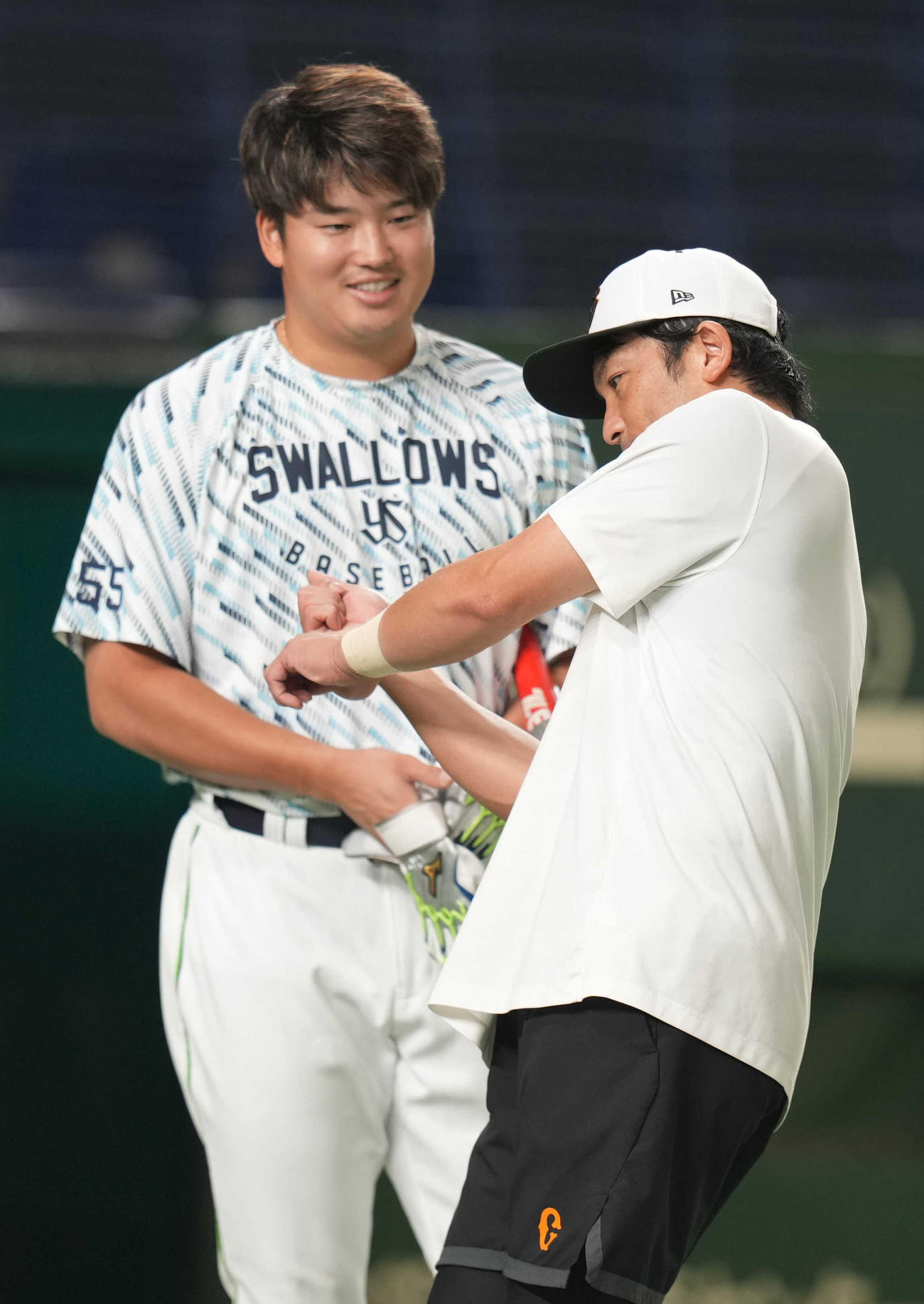 巨人対ヤクルト　試合前、村上（左）と話をする松田（撮影・狩俣裕三）
