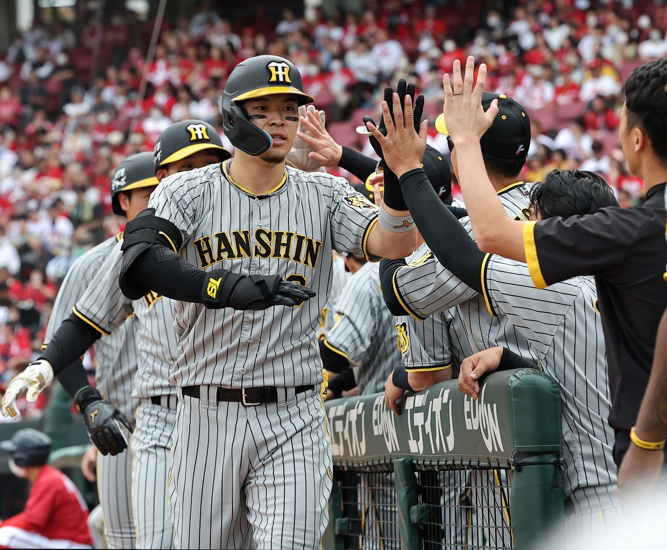 広島対阪神　5回表阪神無死一、二塁、右越え3点本塁打を放った佐藤輝はナインとハイタッチをする（撮影・上田博志）